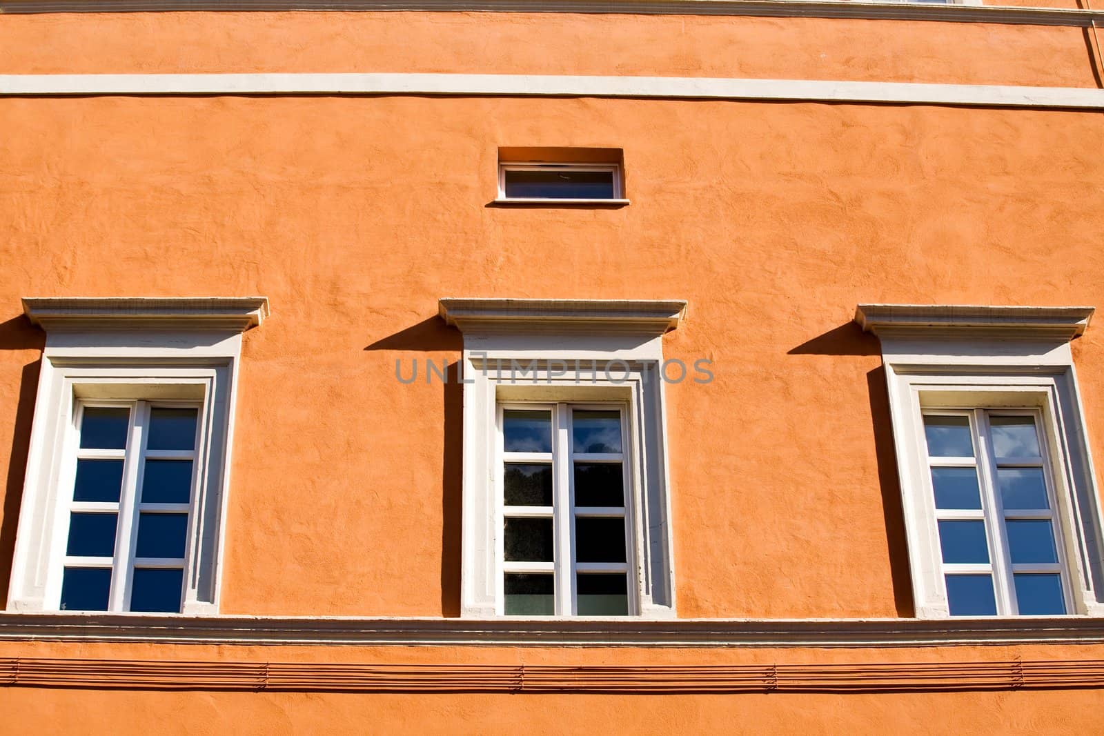 Windows on orange wall in Rome, Italy