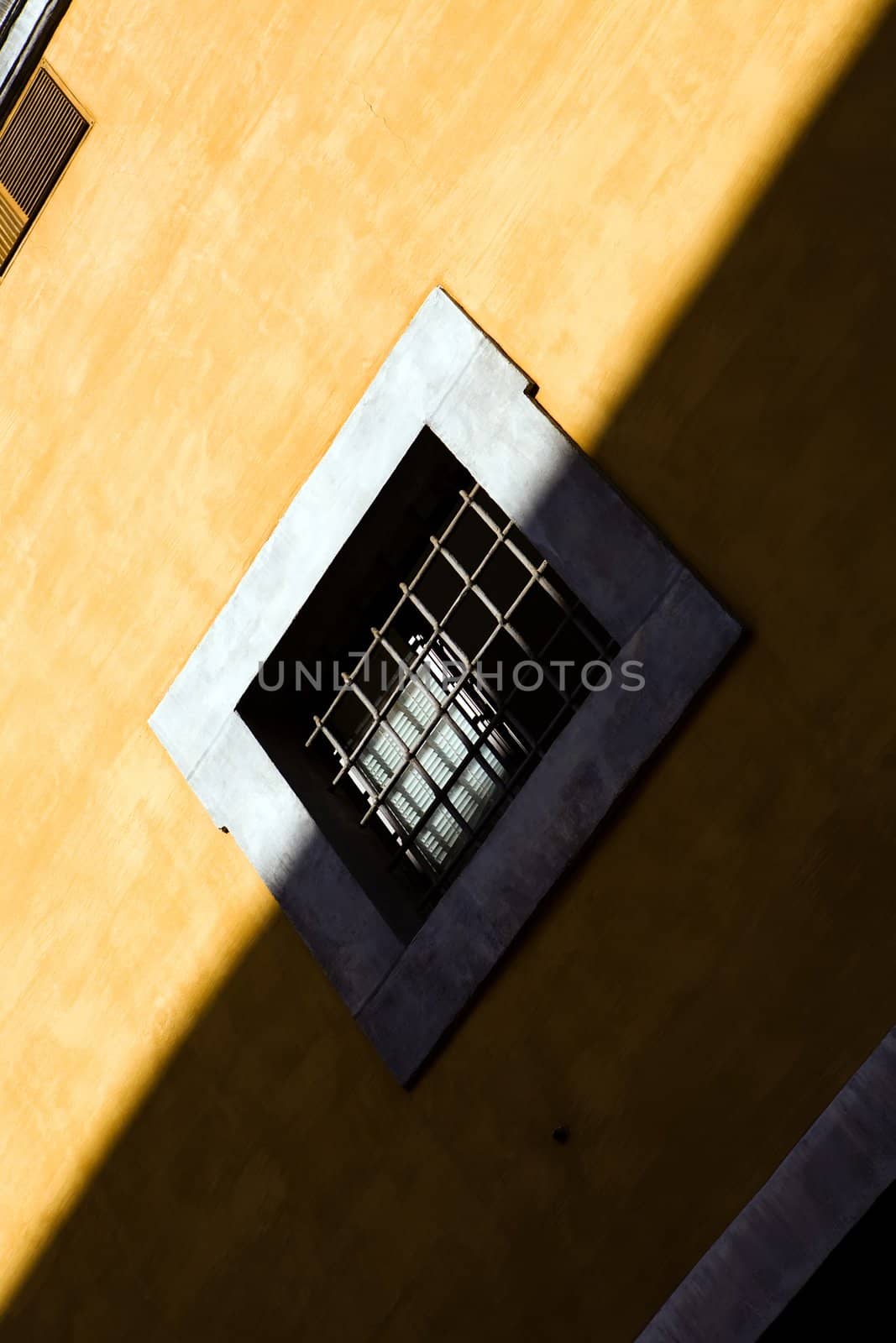 Window on yellow wall in Rome, Italy