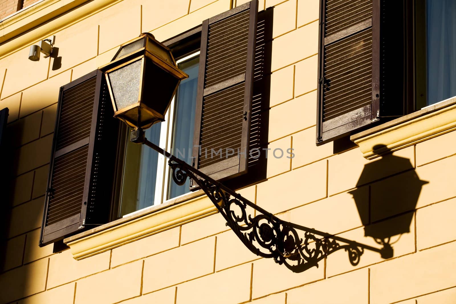 Windows on yellow wall in Rome, Italy