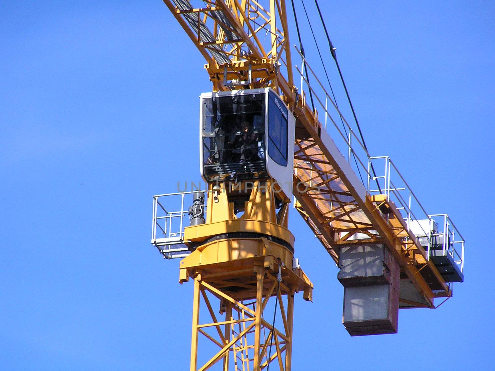 Yellow tower crane against a blue sky