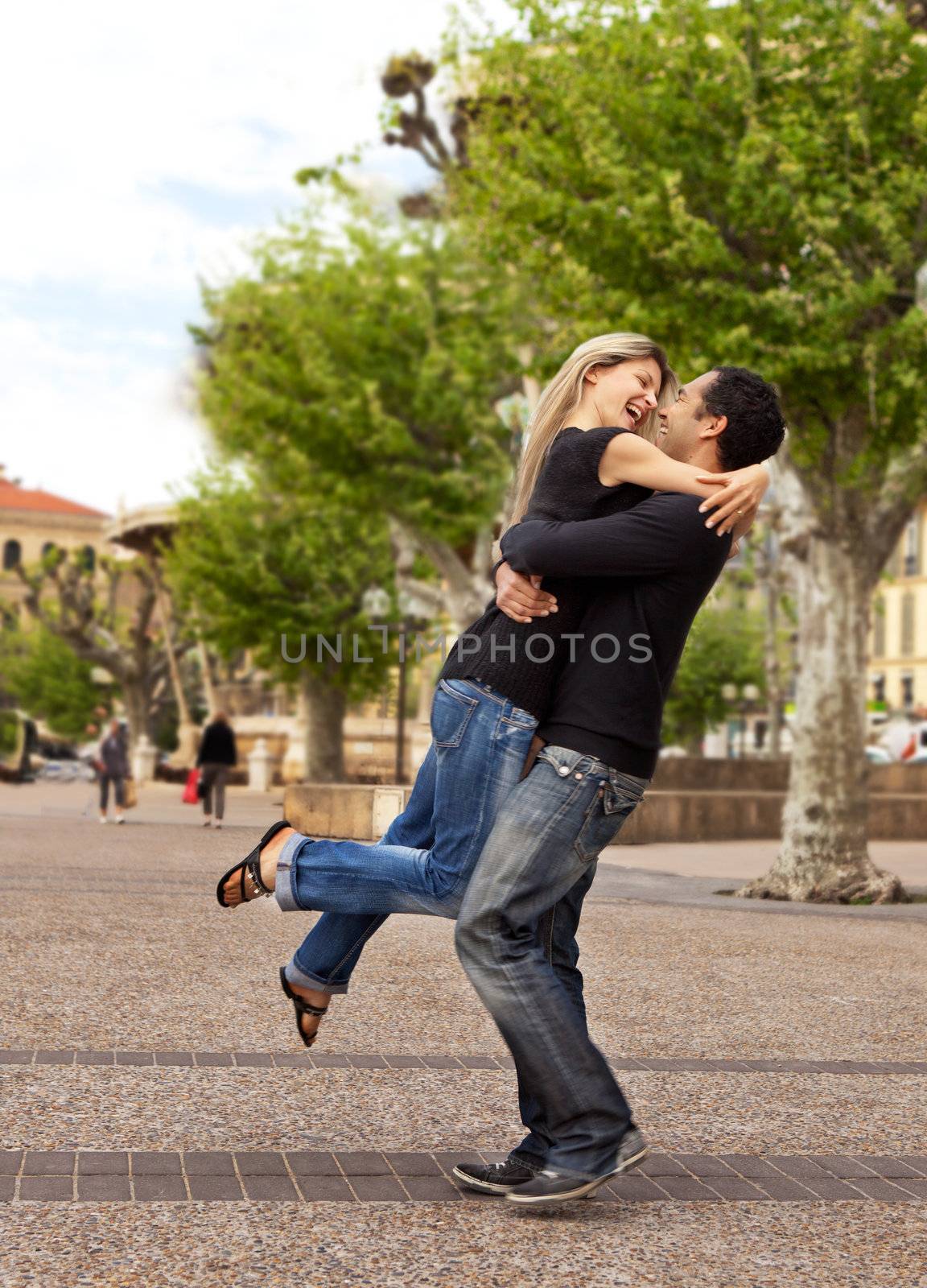 A happy european couple - the man lifting and hugging the woman