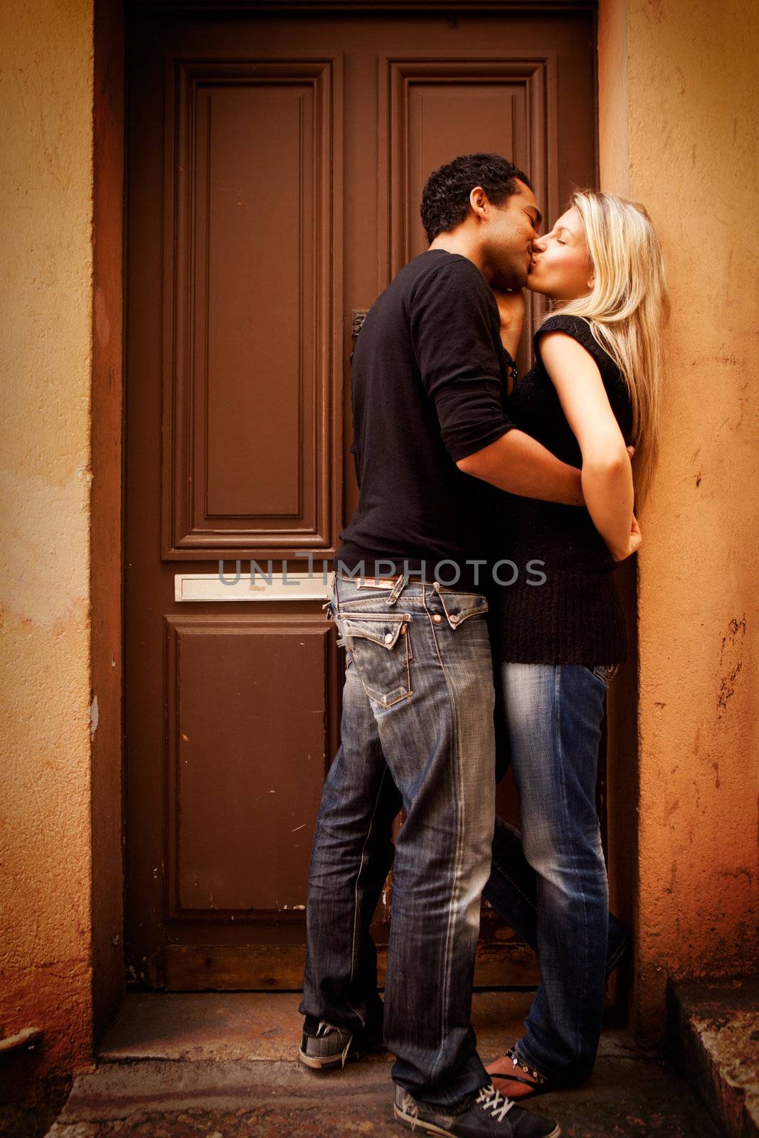 A couple kissing in an urban European setting