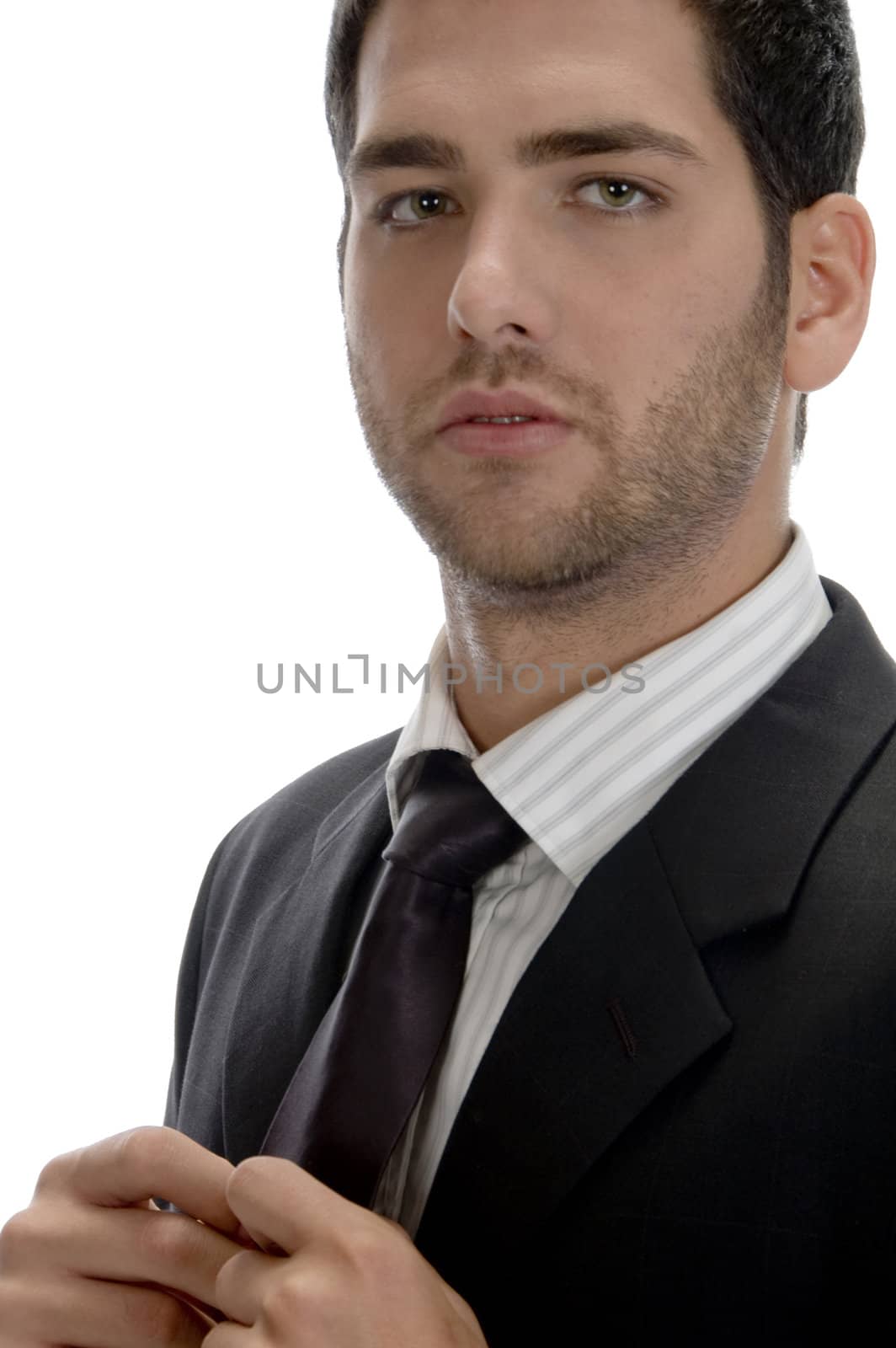 businessman holding tie and looking to camera on an isolated white background