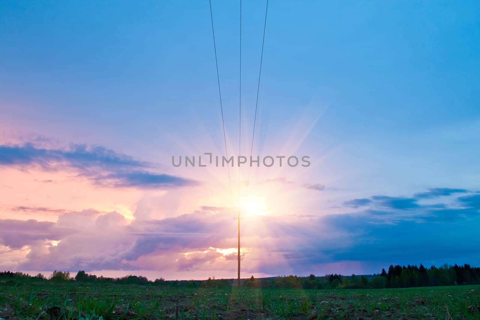 crimson dramatic sunset over the field with power line