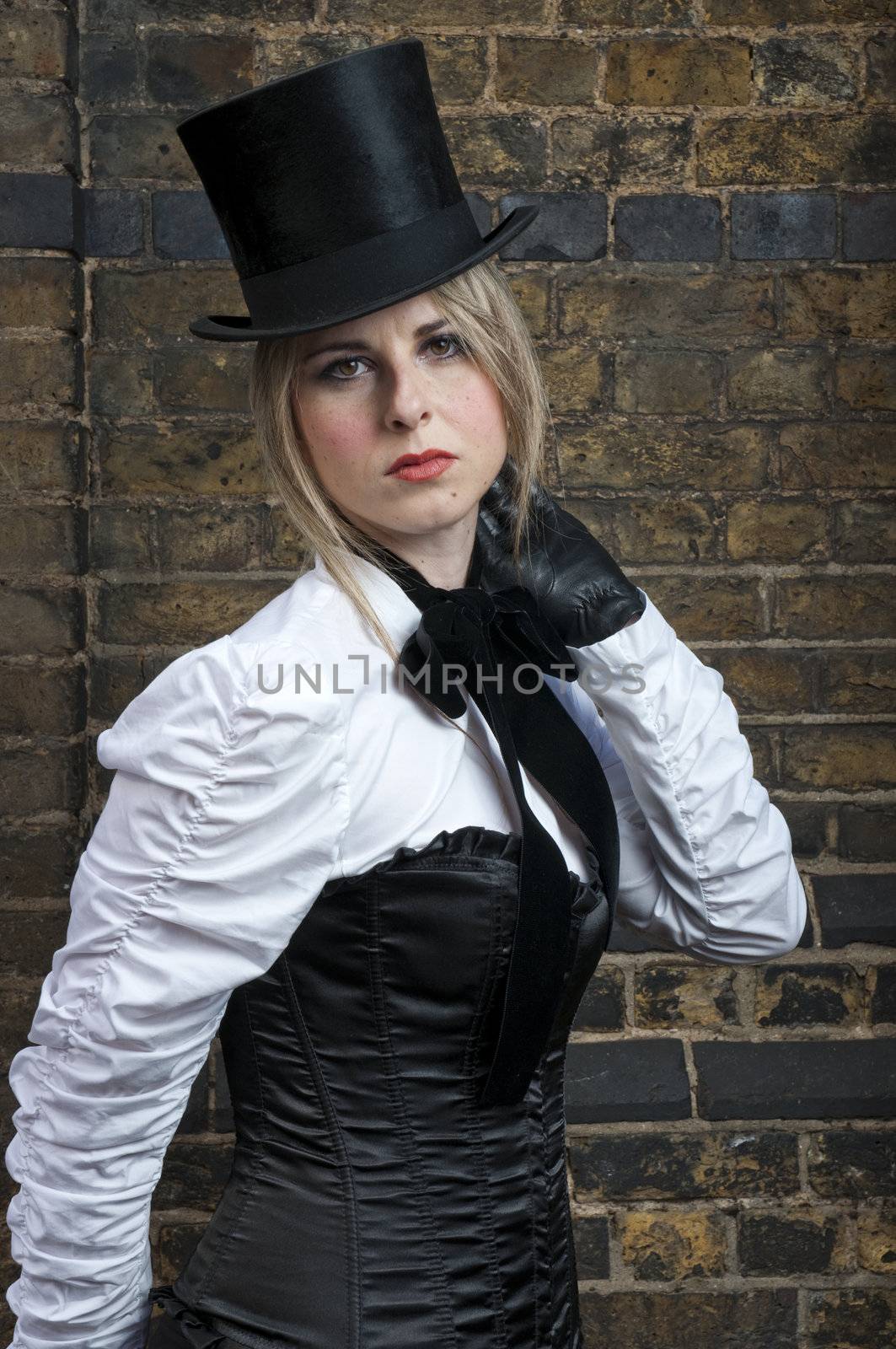 Portrait of beautiful woman in late victorian costume against brick wall