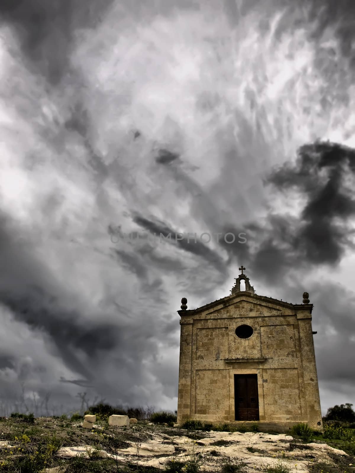 A medieval little chapel against a raging sky