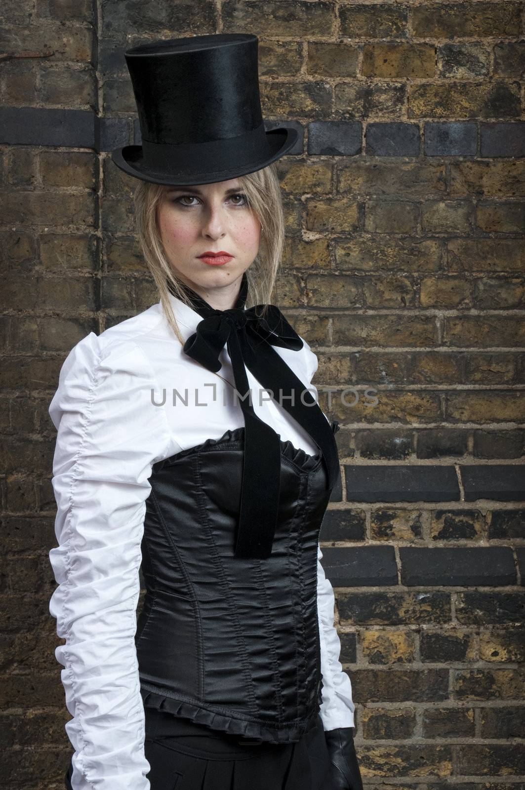 Portrait of beautiful woman in late victorian costume against brick wall