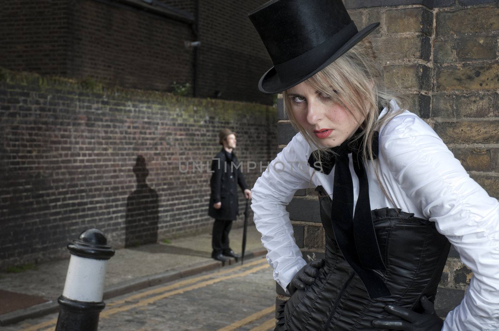 Street Fashion shot of woman in late victorian clothes with man in the background.