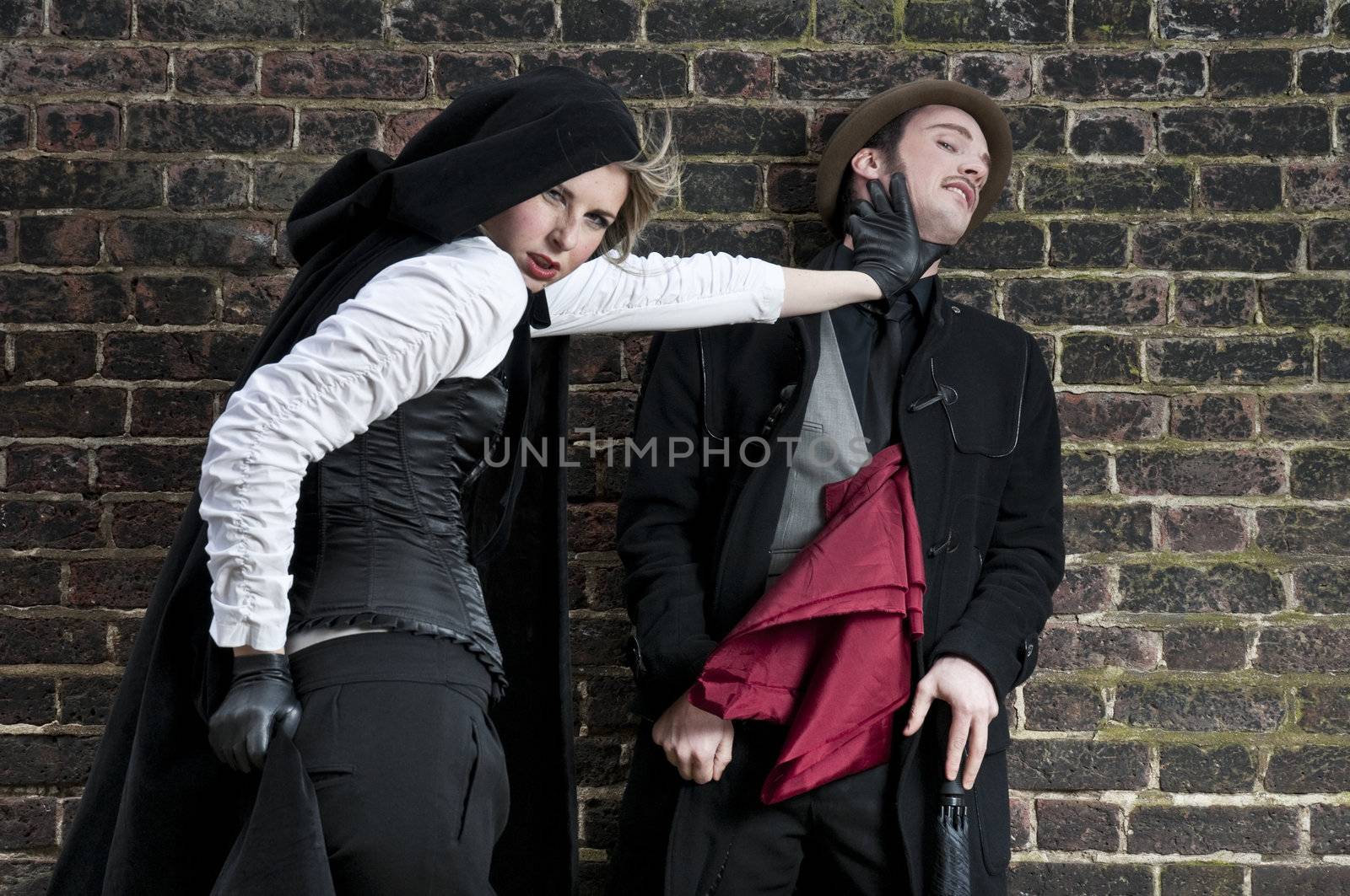 Couple in victorian costumes, woman strangling man.