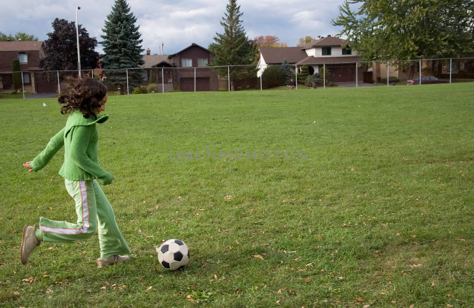 A girl kicking a soccer ball