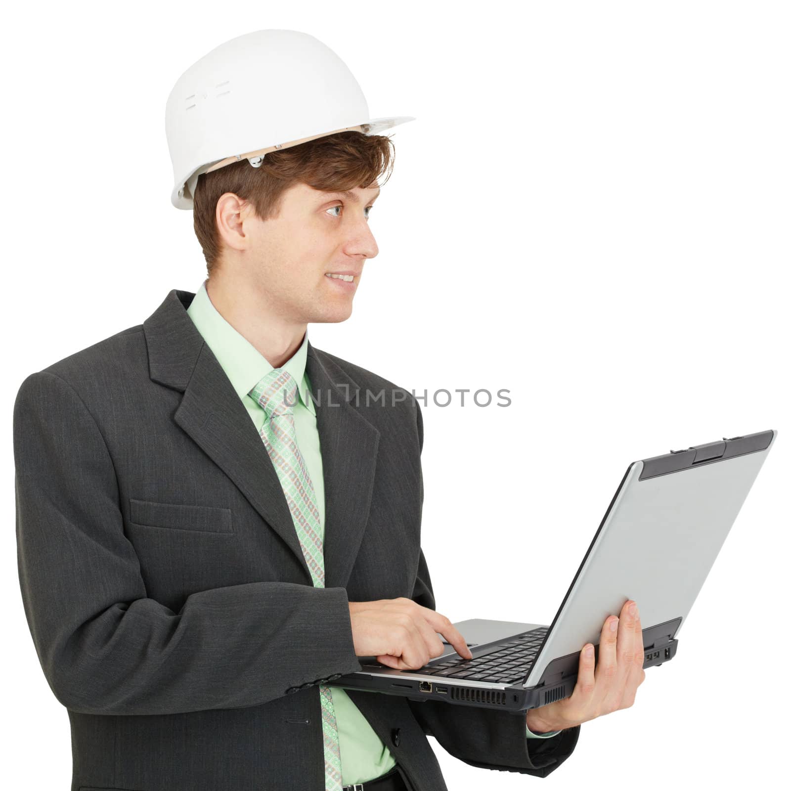 The smiling engineer in a white helmet with the laptop in hands