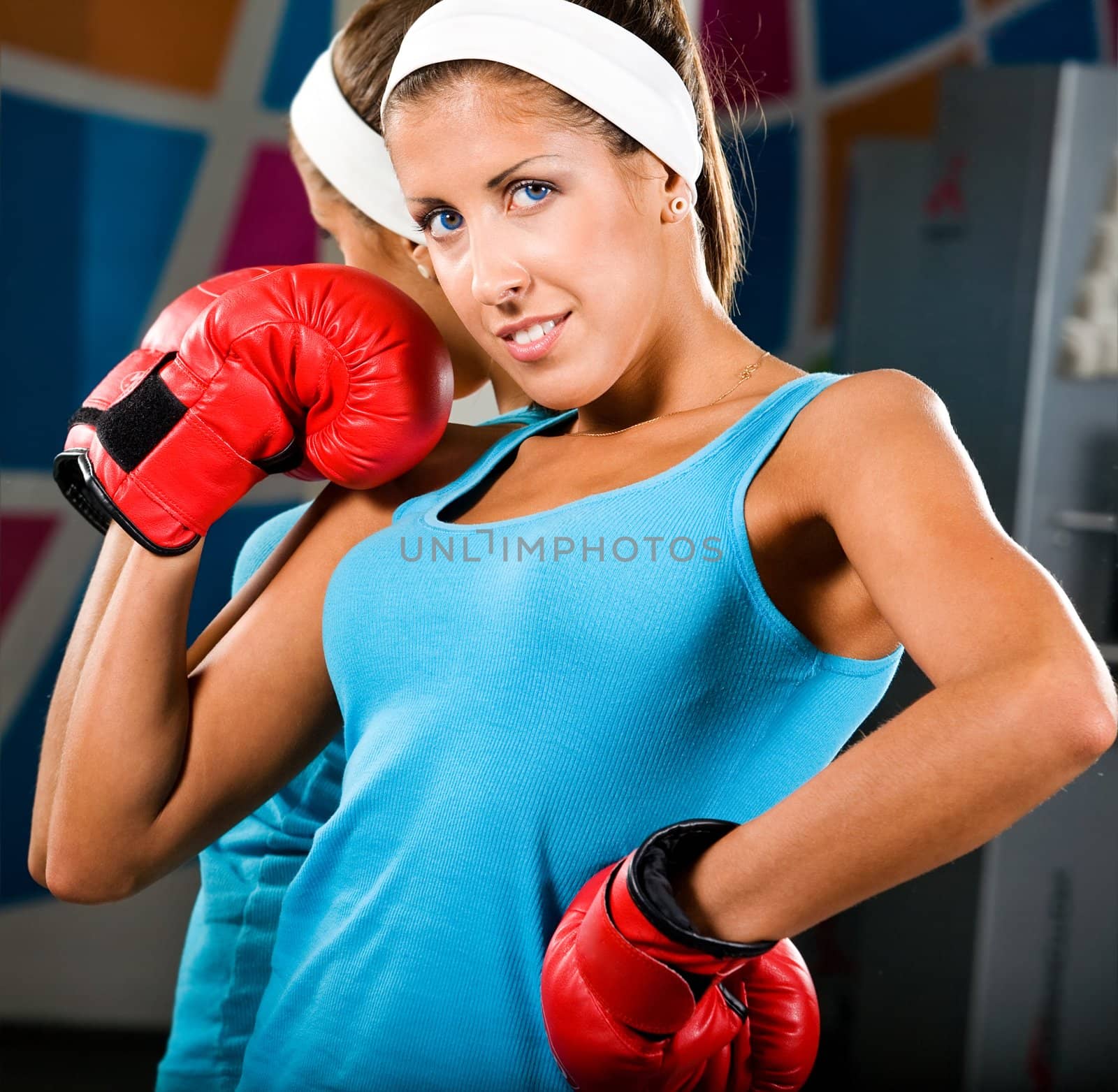 Attractive young woman with red boxing gloves in gym