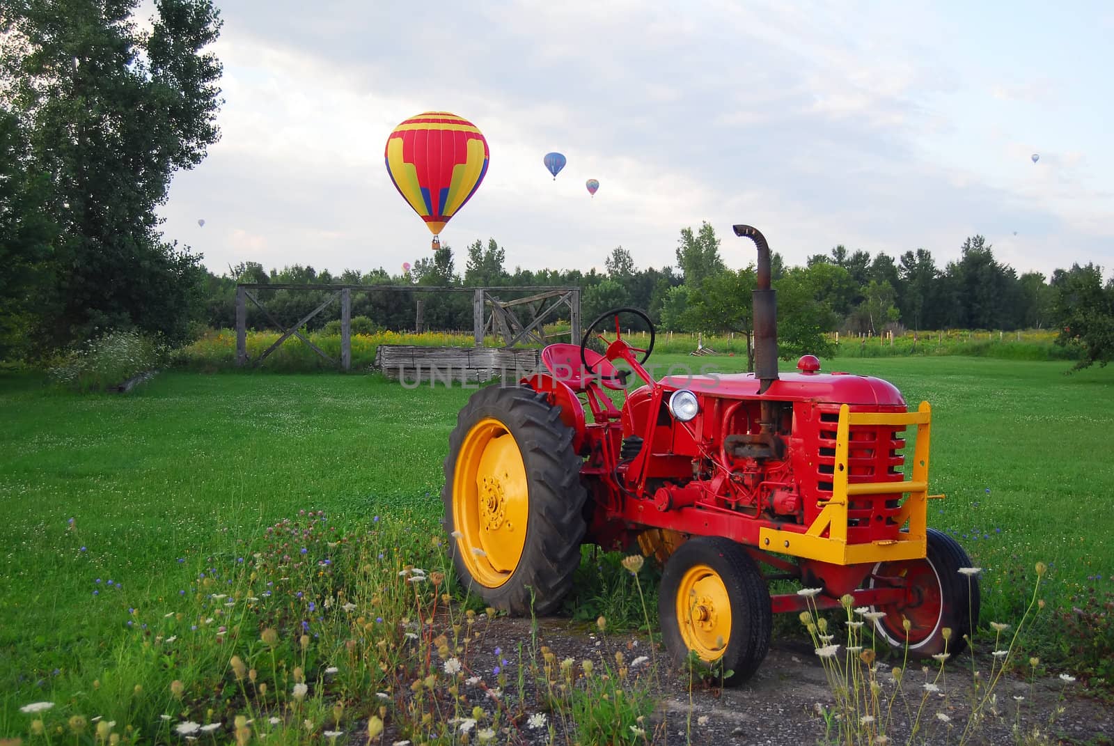 Hot Air Balloons over a field and an old tractor