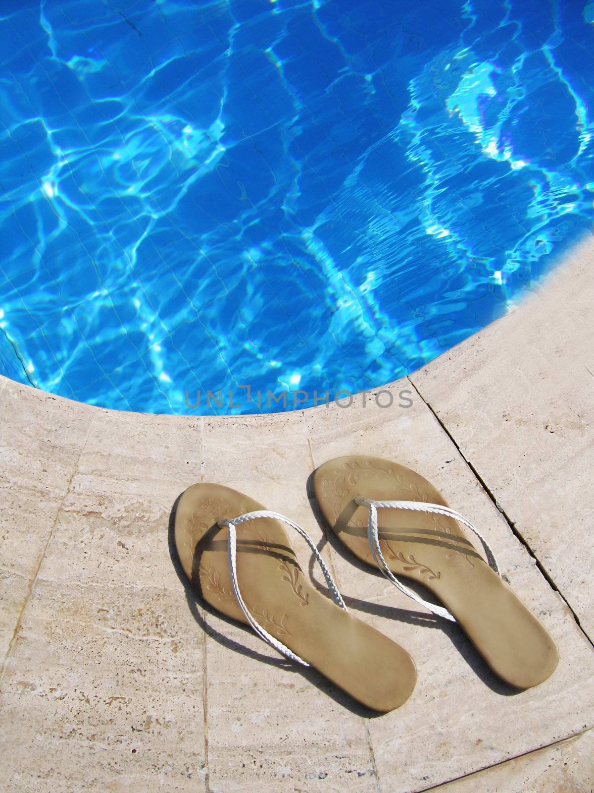 flip-flops by blue swimming pool