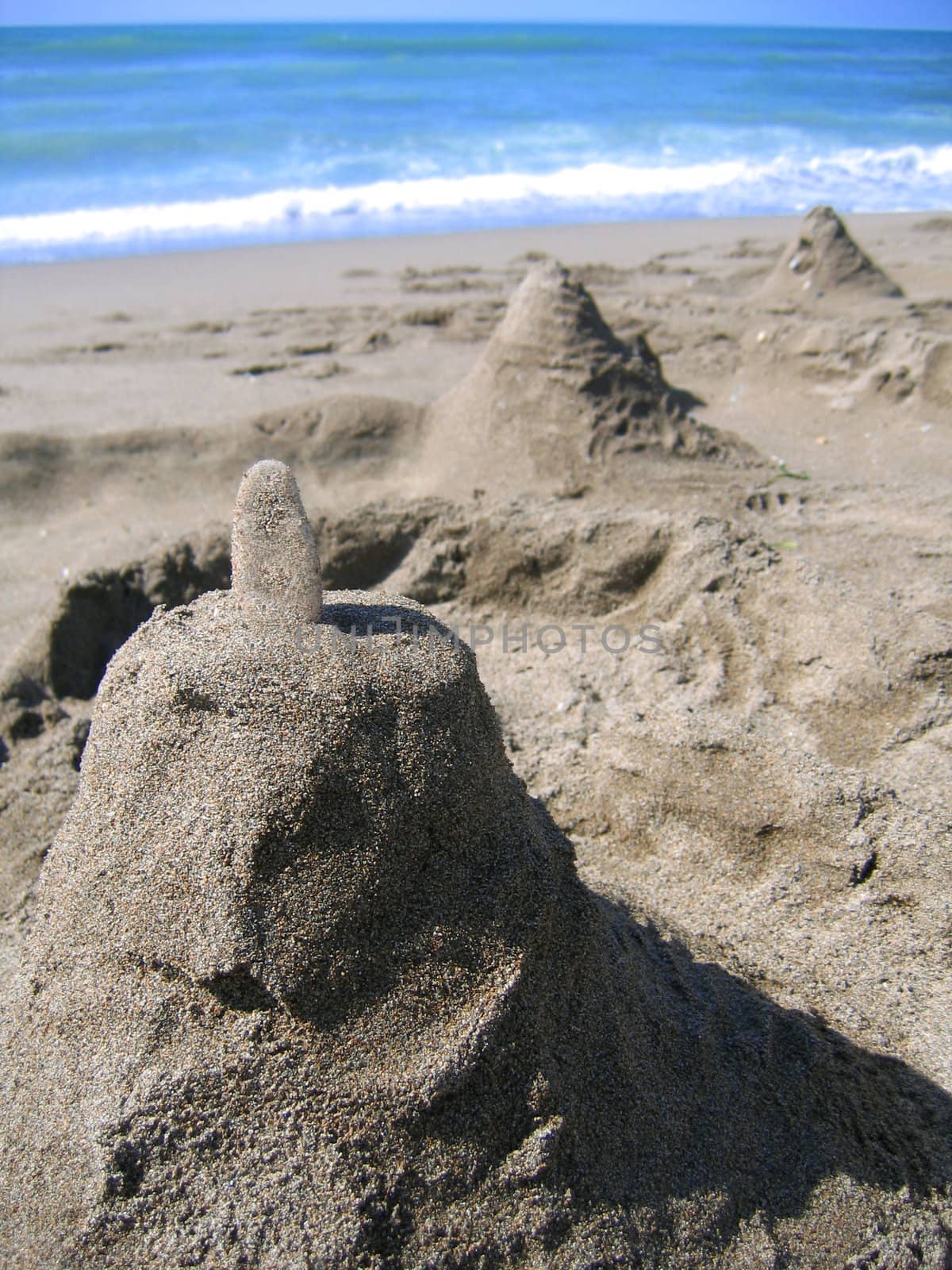 sandcastle on the beach with sea on the background