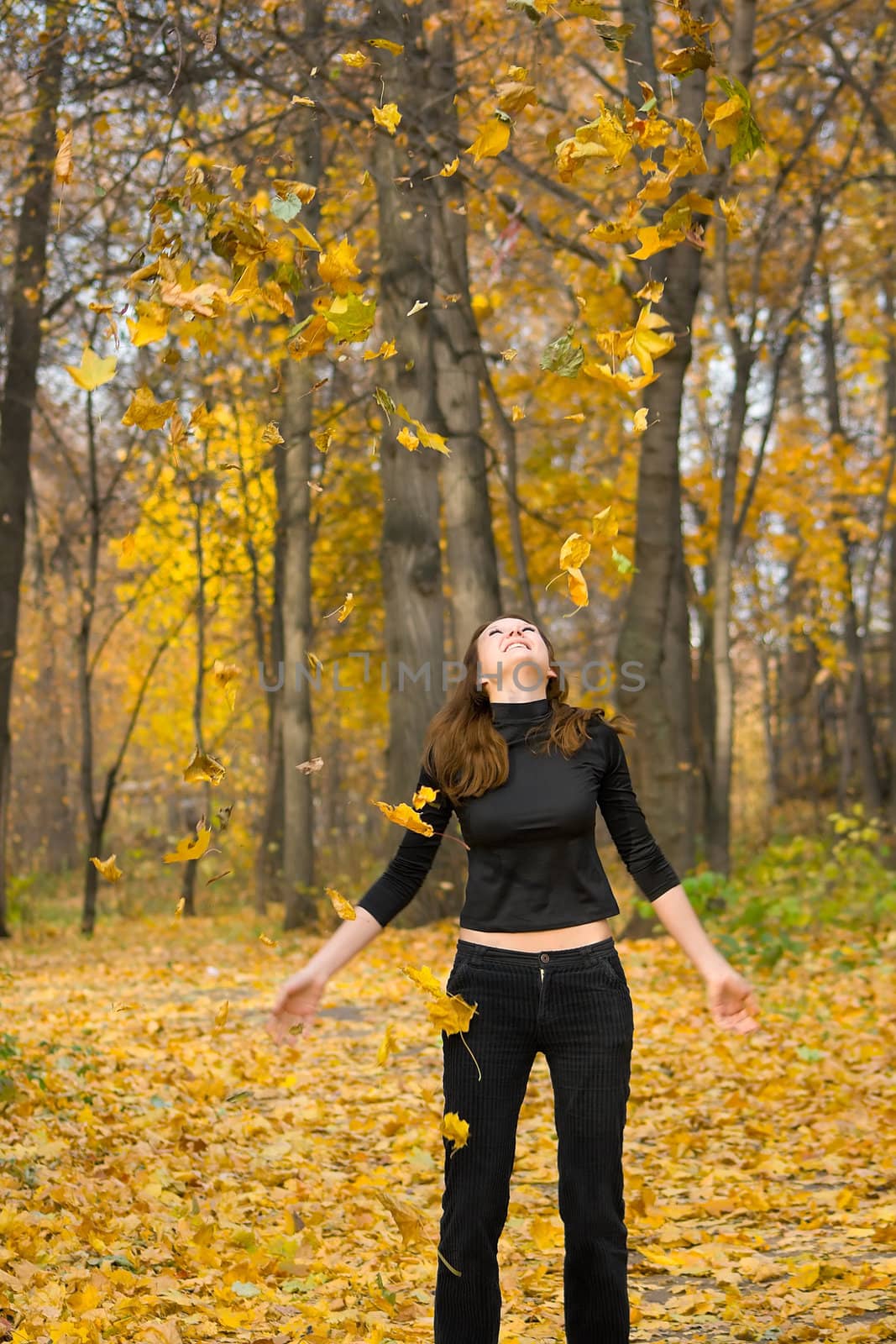 The young girl in autumn park during a leaf fall