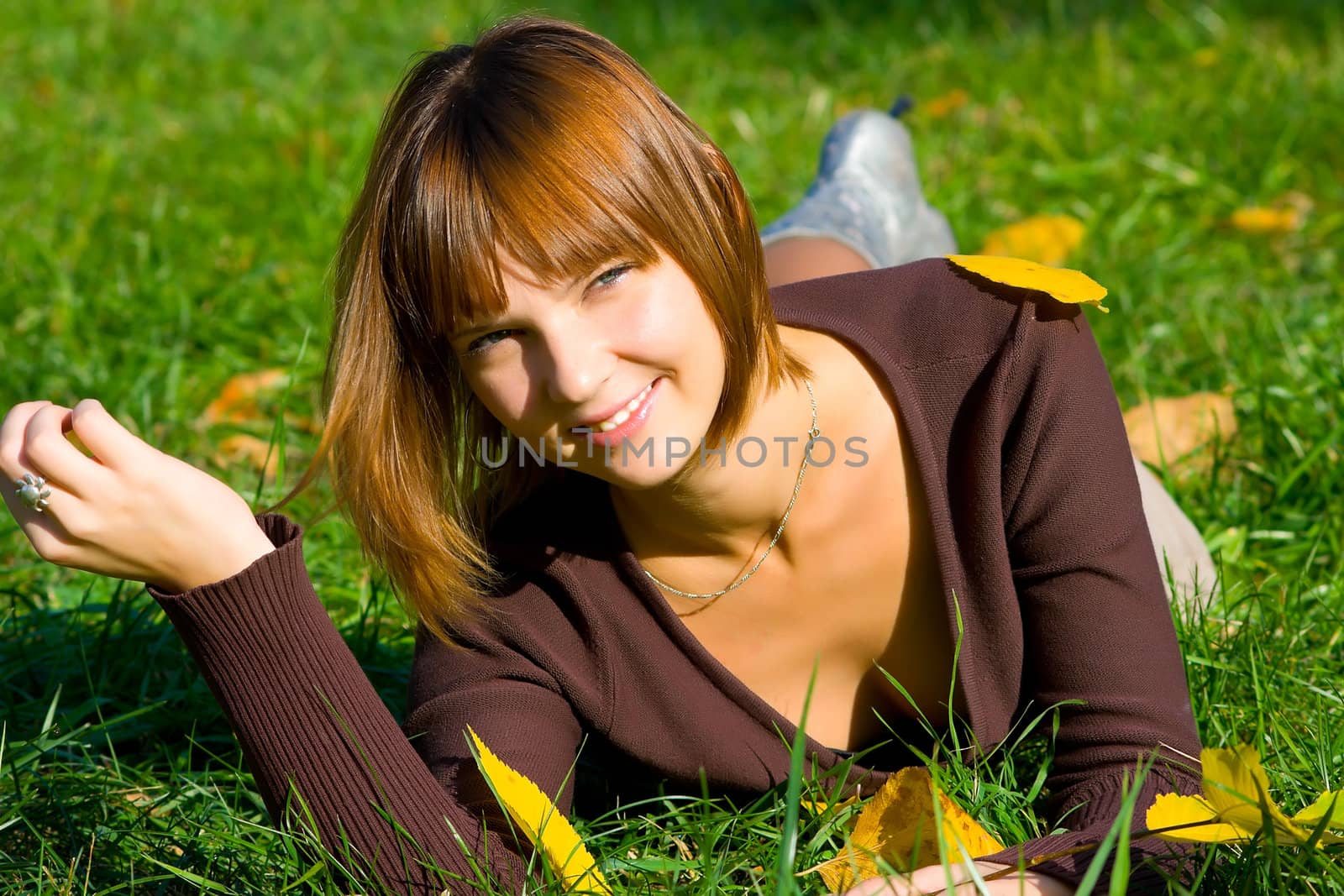 The young girl in autumn park during a leaf fall