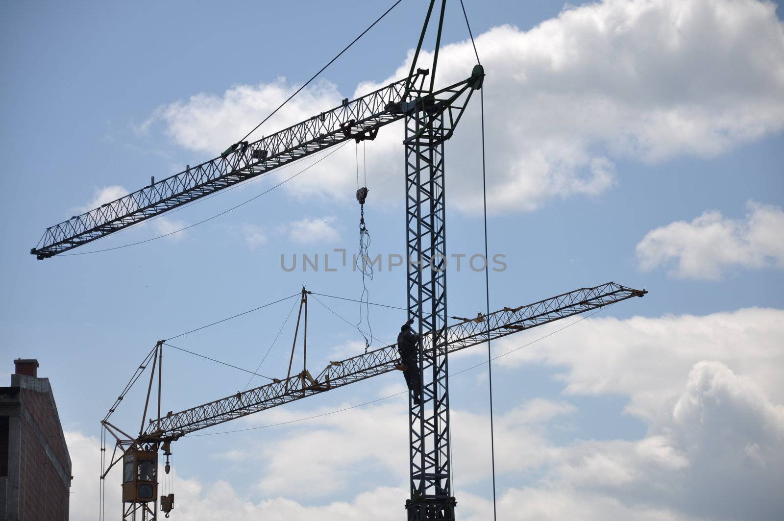 cranes on construction site with a background of blue sky  by costarico