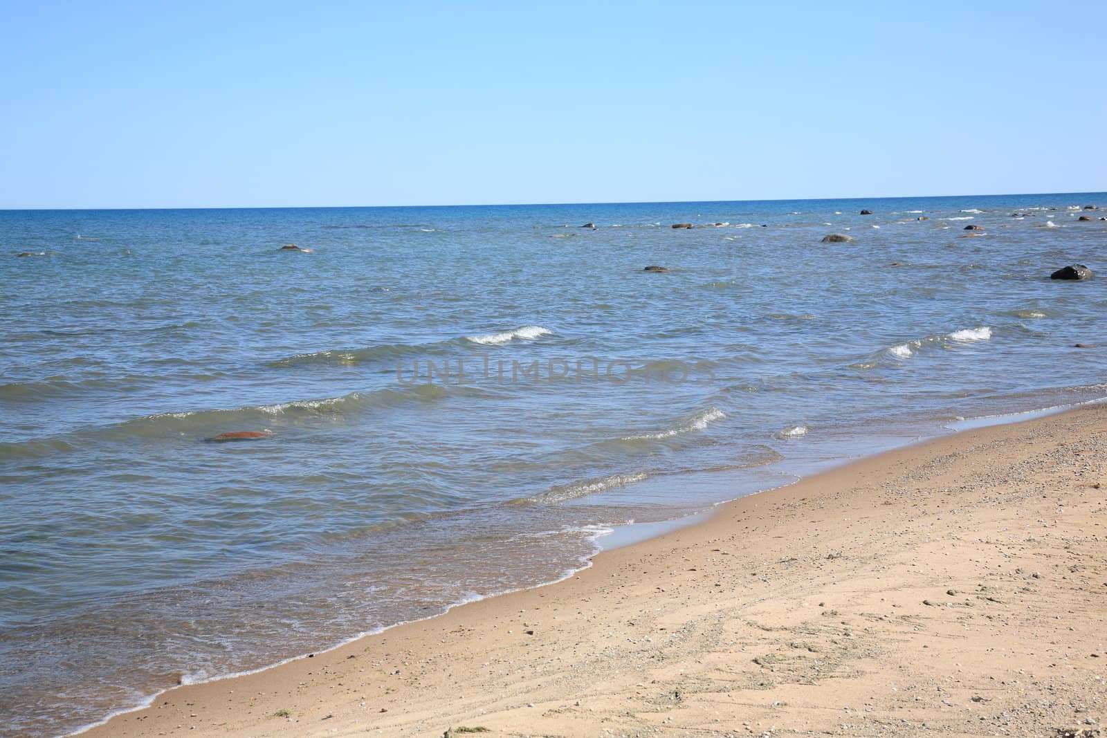 Waves reach sandy beach shoreline of Great Lake