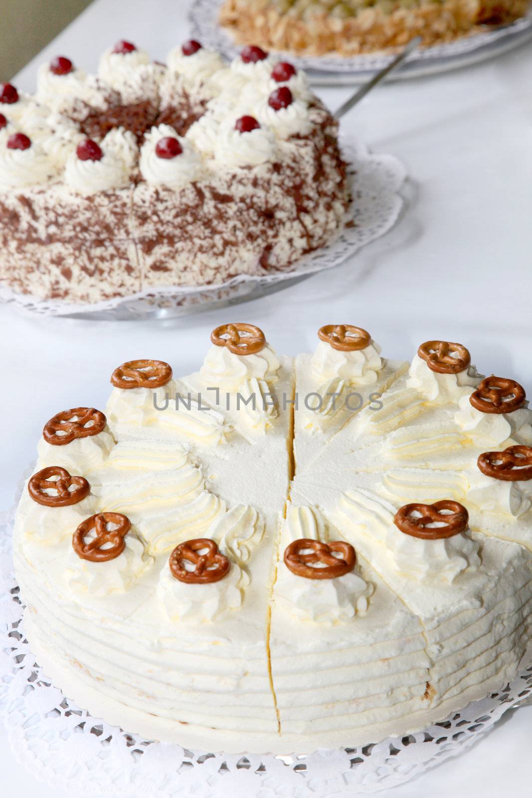 Cake buffet with different cakes. A cream pie is seen in the foreground