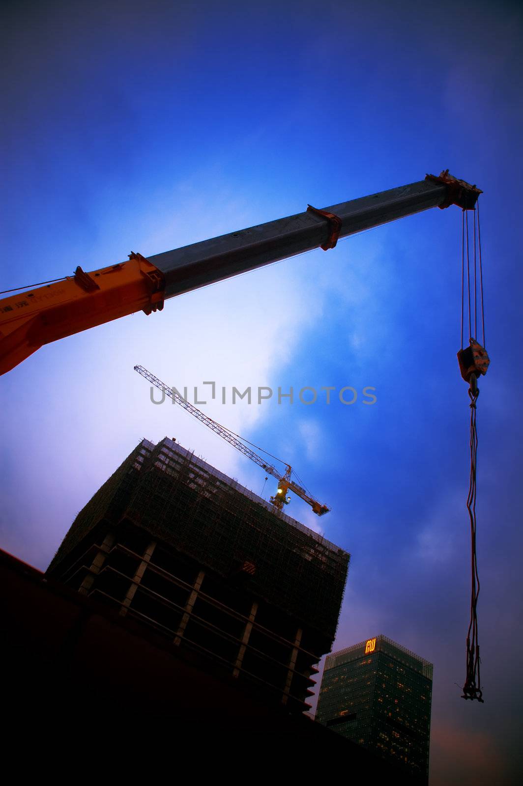 construction cranes on night ove a blue sky