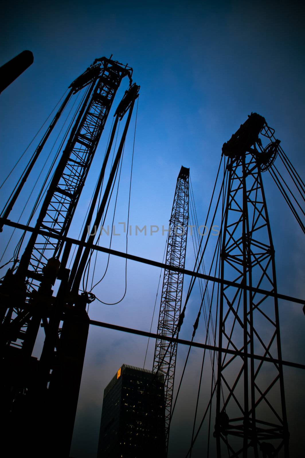 construction cranes on night ove a blue sky