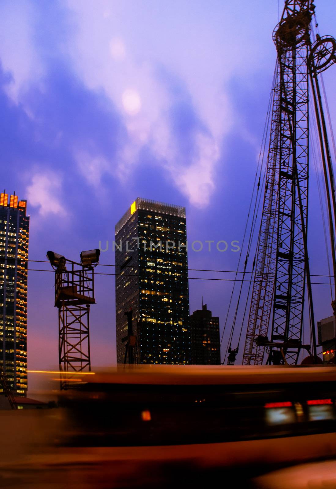 construction cranes on night ove a blue sky