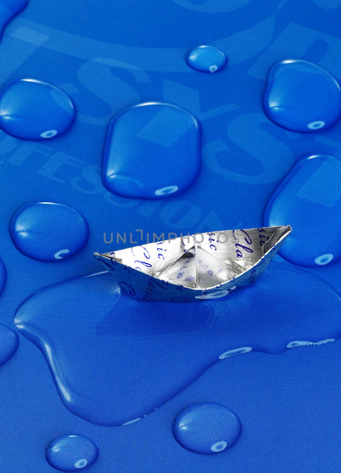 paper boat floating on water drops ,over blue background