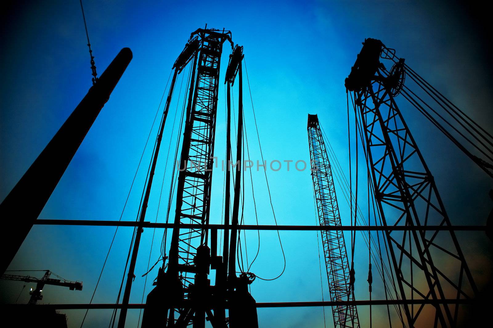 construction cranes on night ove a blue sky