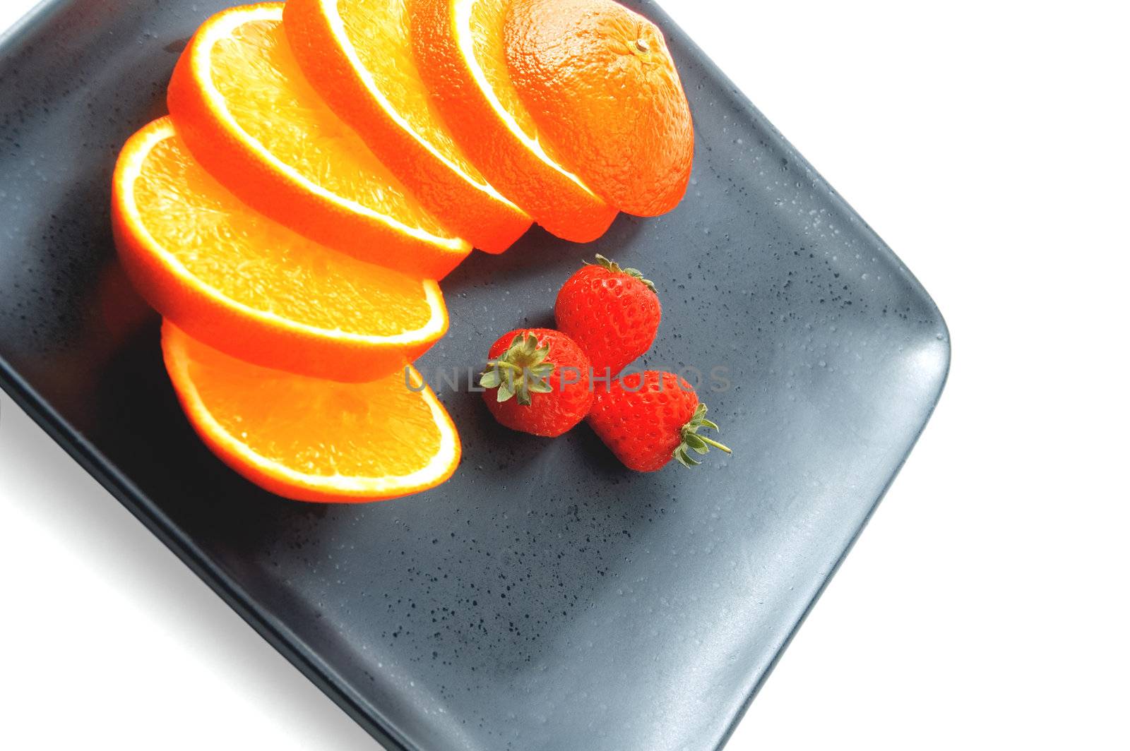 orange & strawberries on a plate on white background