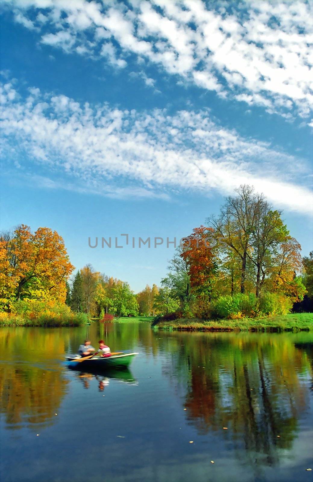 Humans rowing in the boat in autumn day