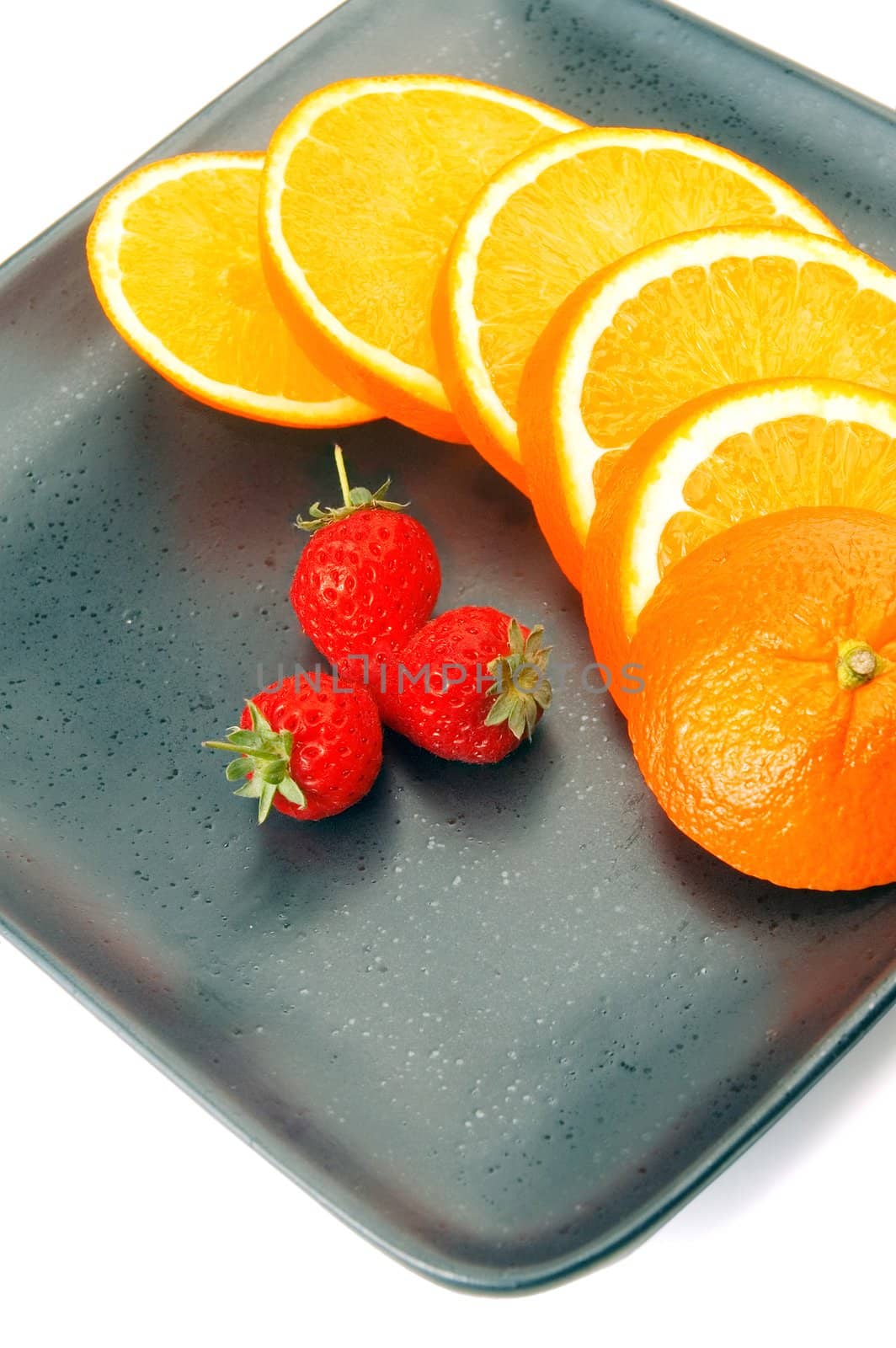 orange & strawberries on a plate on white background