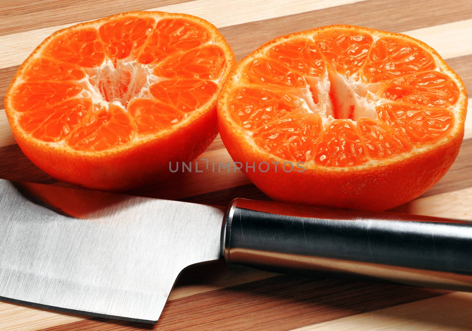 orange mandarin tangerine on cutting board with stainless steel knife