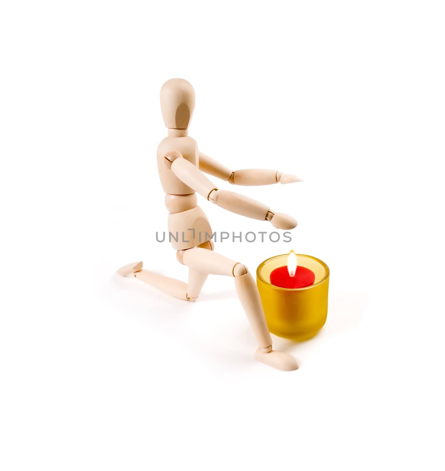 wood mannequin near a candle on white background