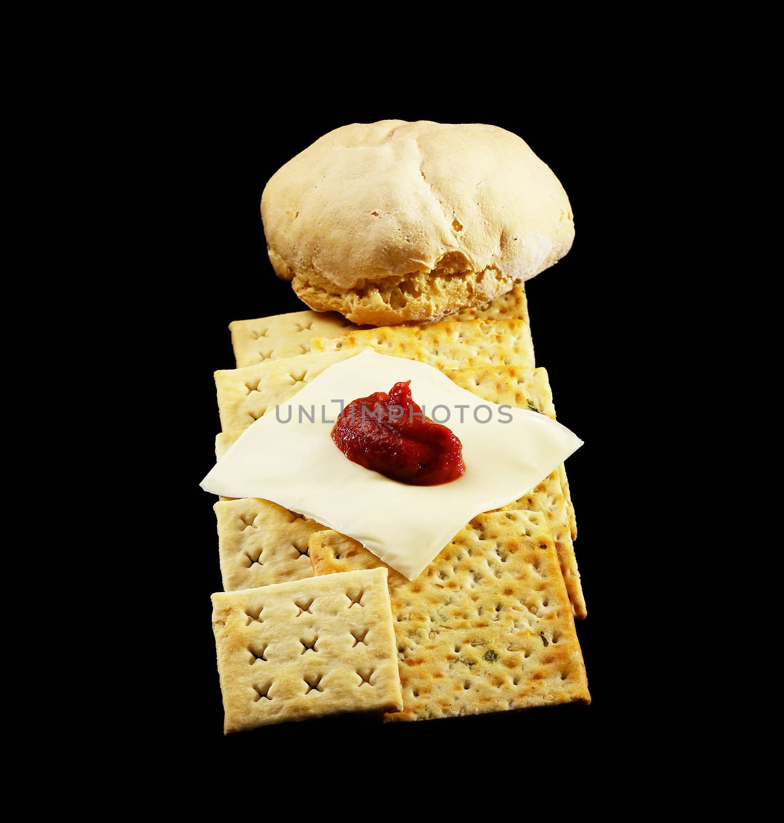 bread and crackers with cheese and tomato on black background