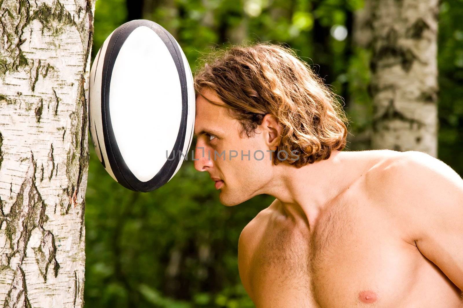 Caucasian strong man playing funny rugby ball outdoors