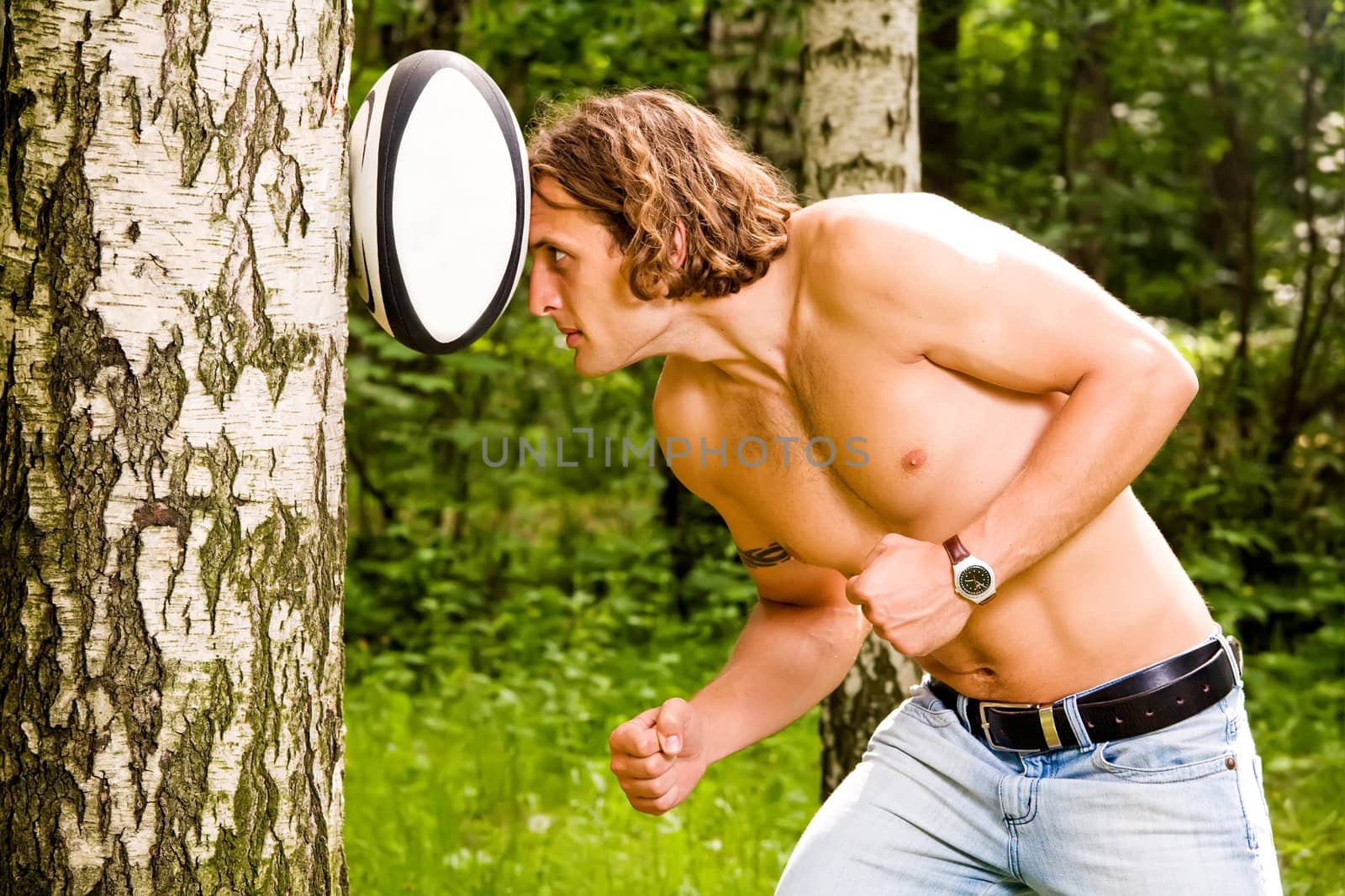 Caucasian strong man playing funny rugby ball outdoors