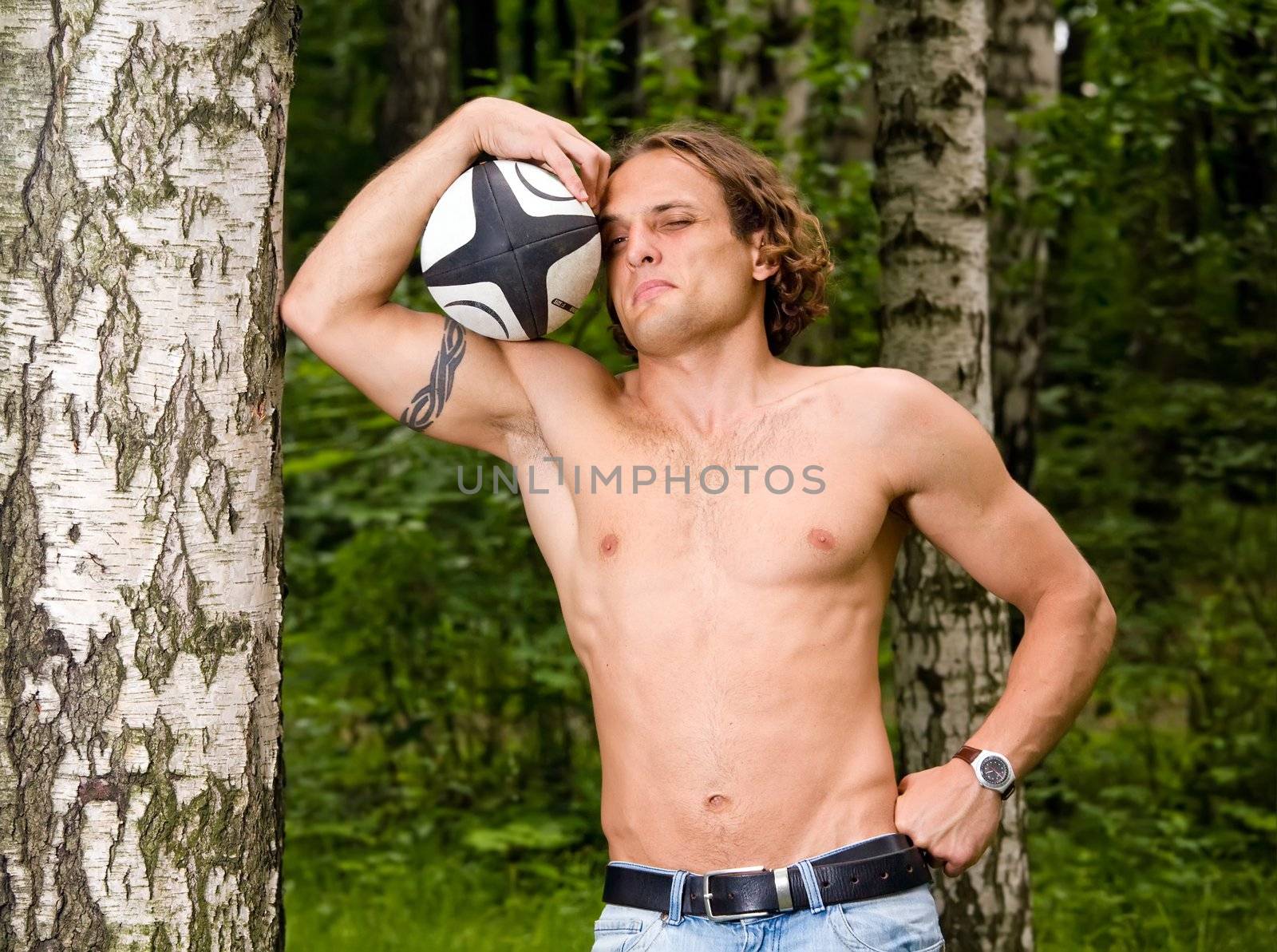 Caucasian strong man playing funny rugby ball outdoors