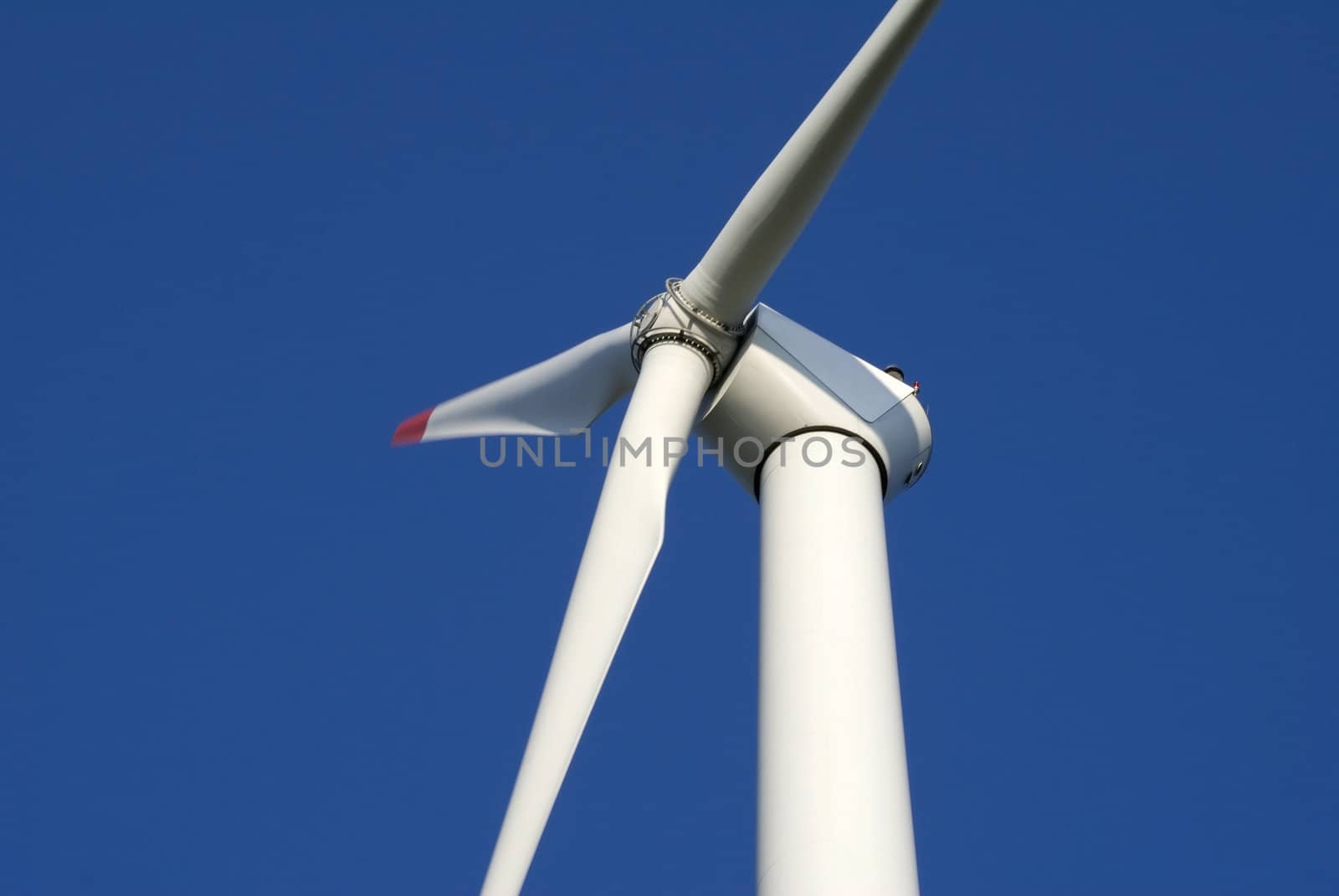 Close-up of wind turbine against blue sky