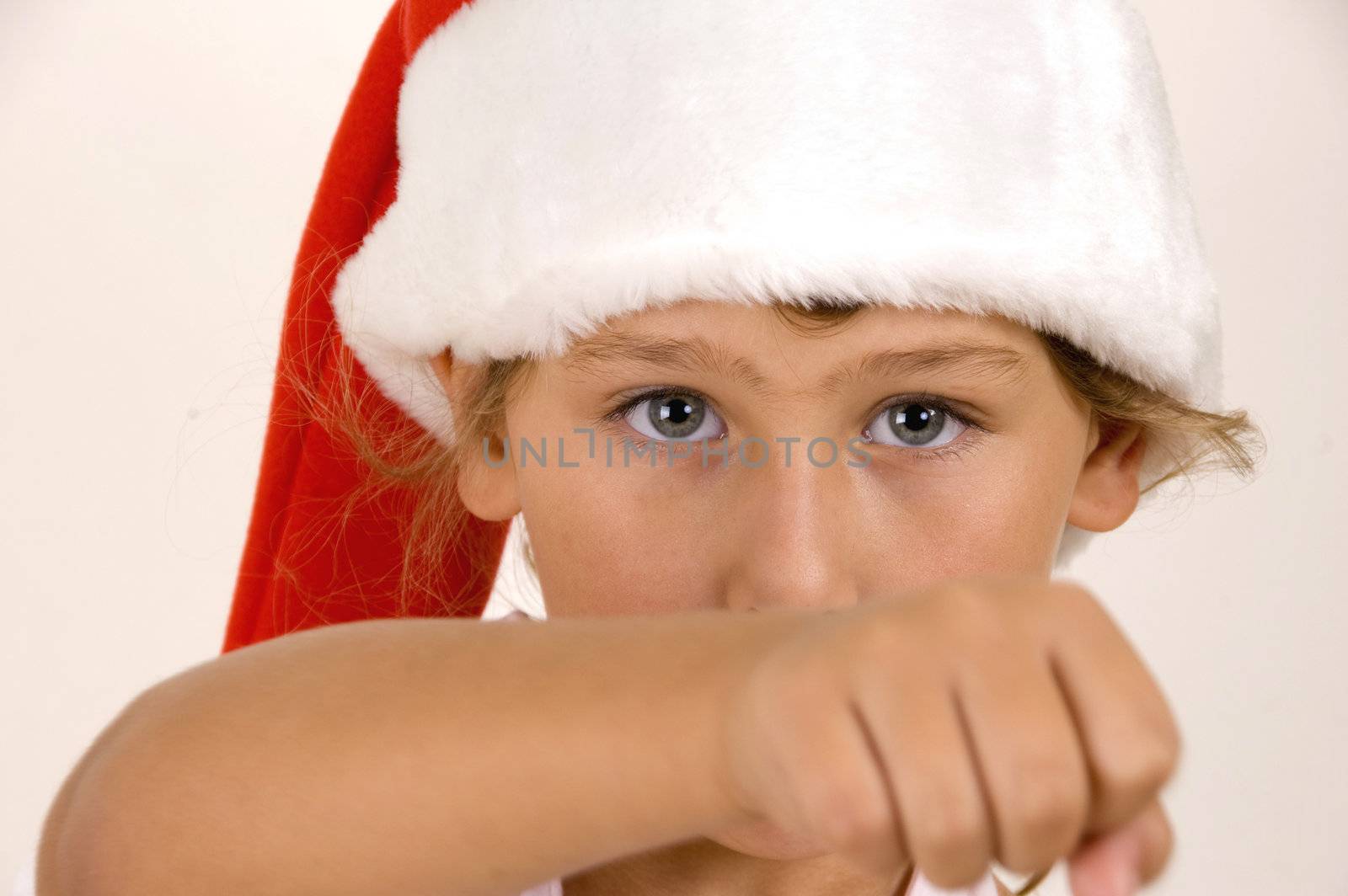 little girl with christmas hat showing punch