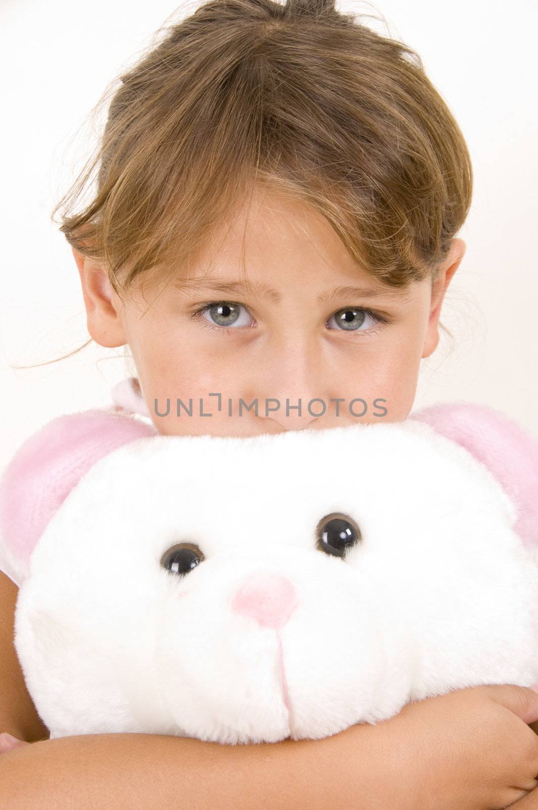 little girl with teddy bear looking you