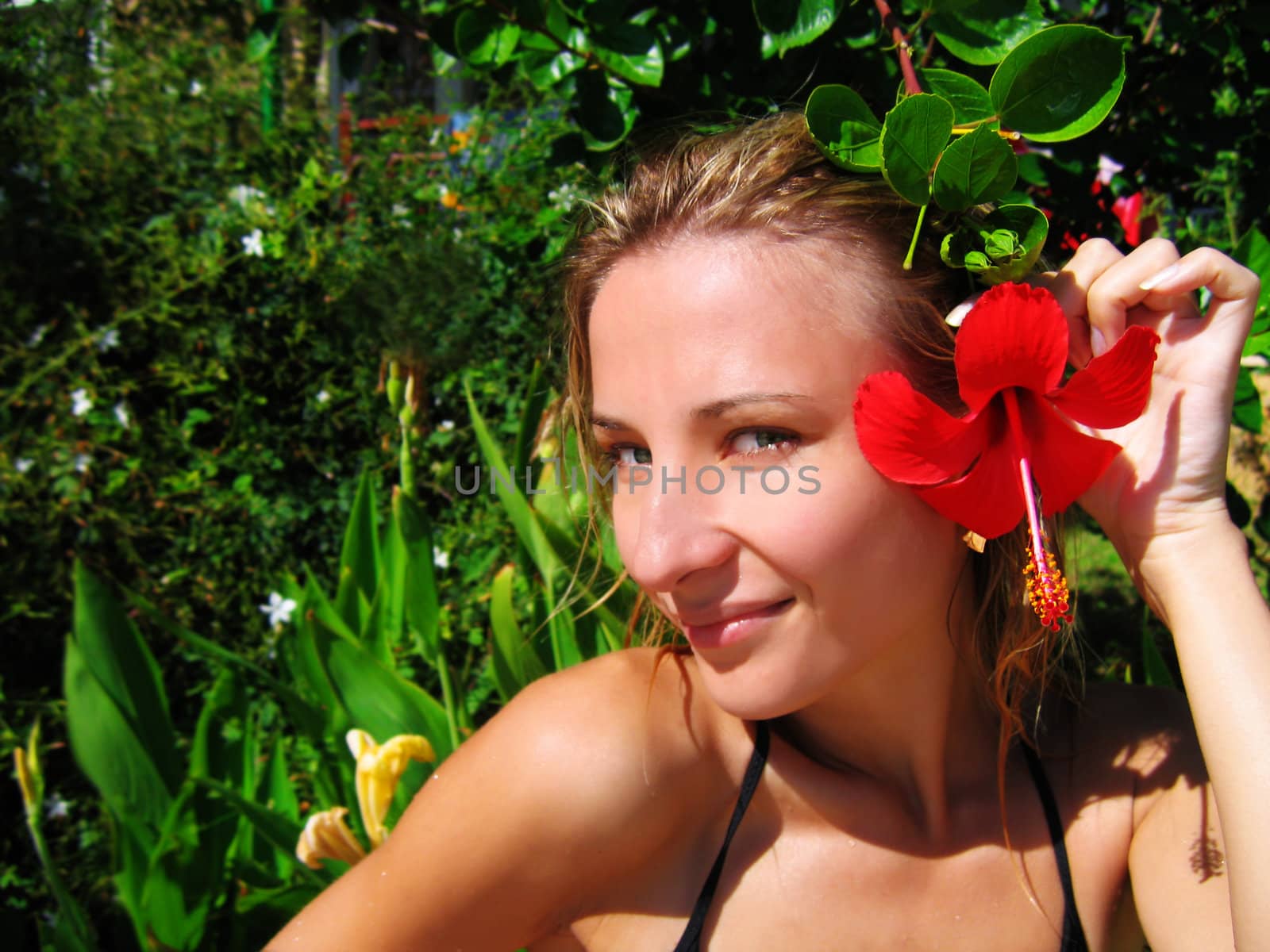 woman with red hibiscus over green