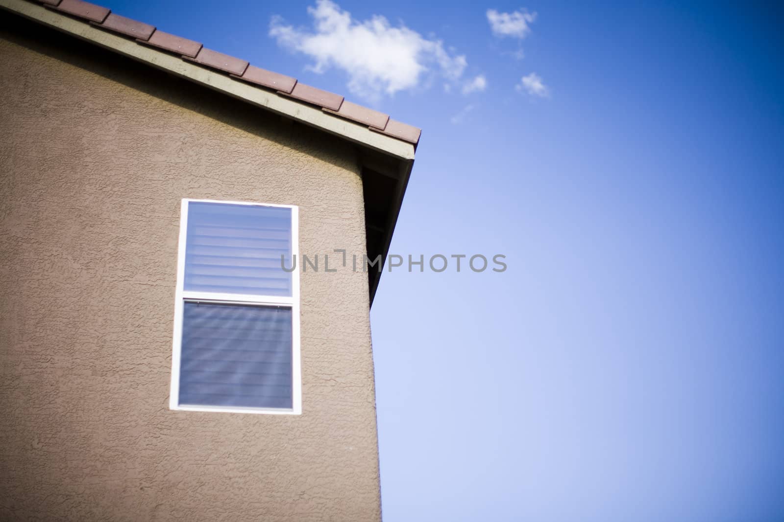 a close-up image of a window on a suburban house with a blue sky in the background outside in las vegas
