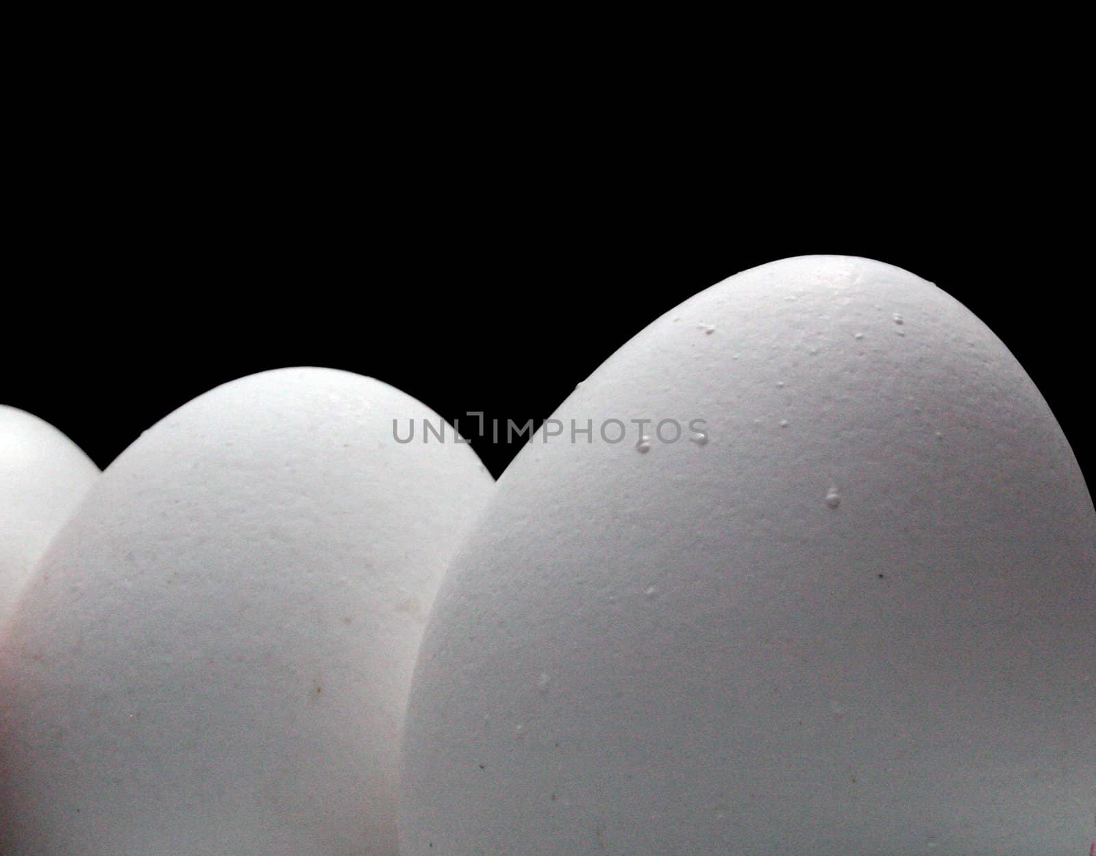 close up three eggs on black background