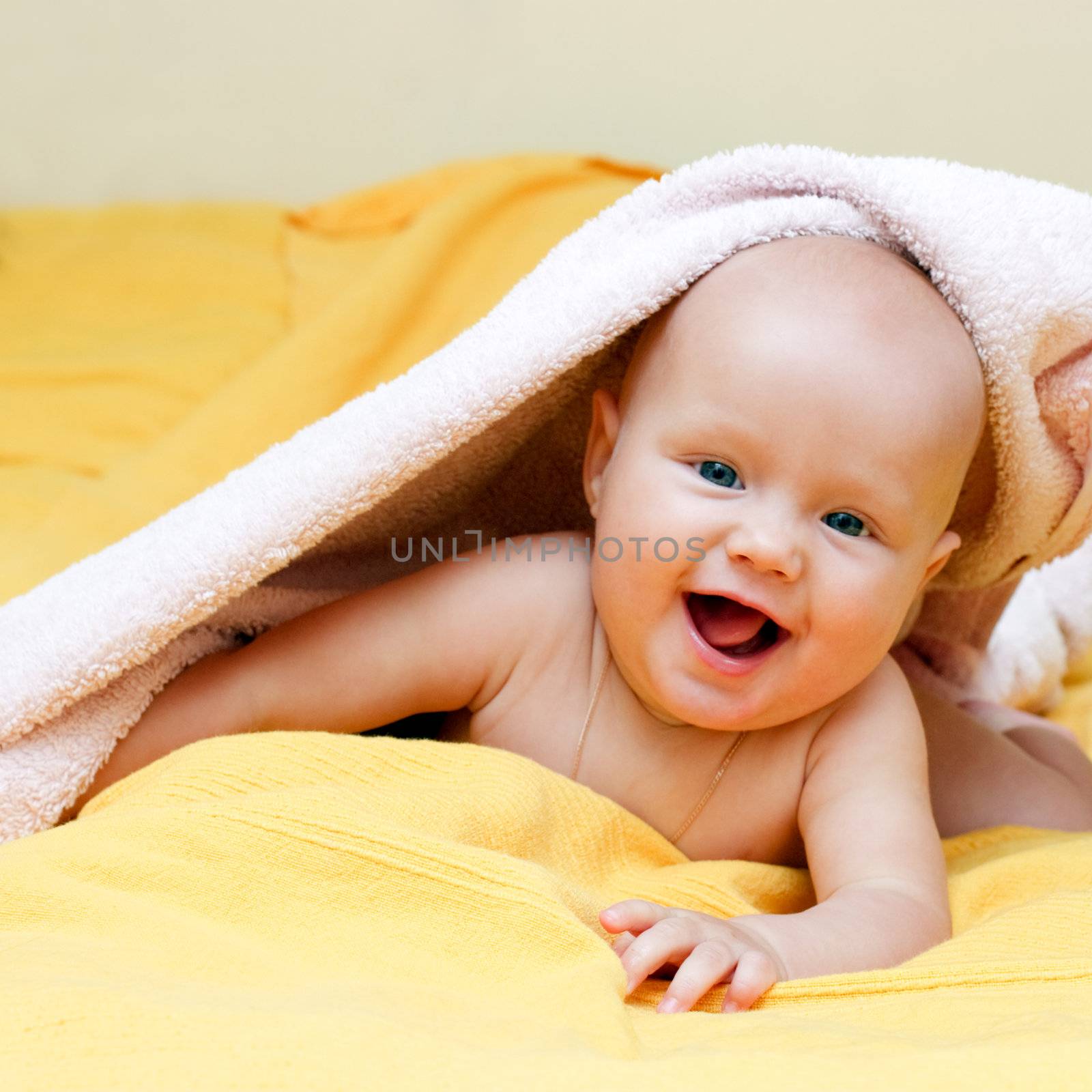 Happy seven month baby girl playing with towel
