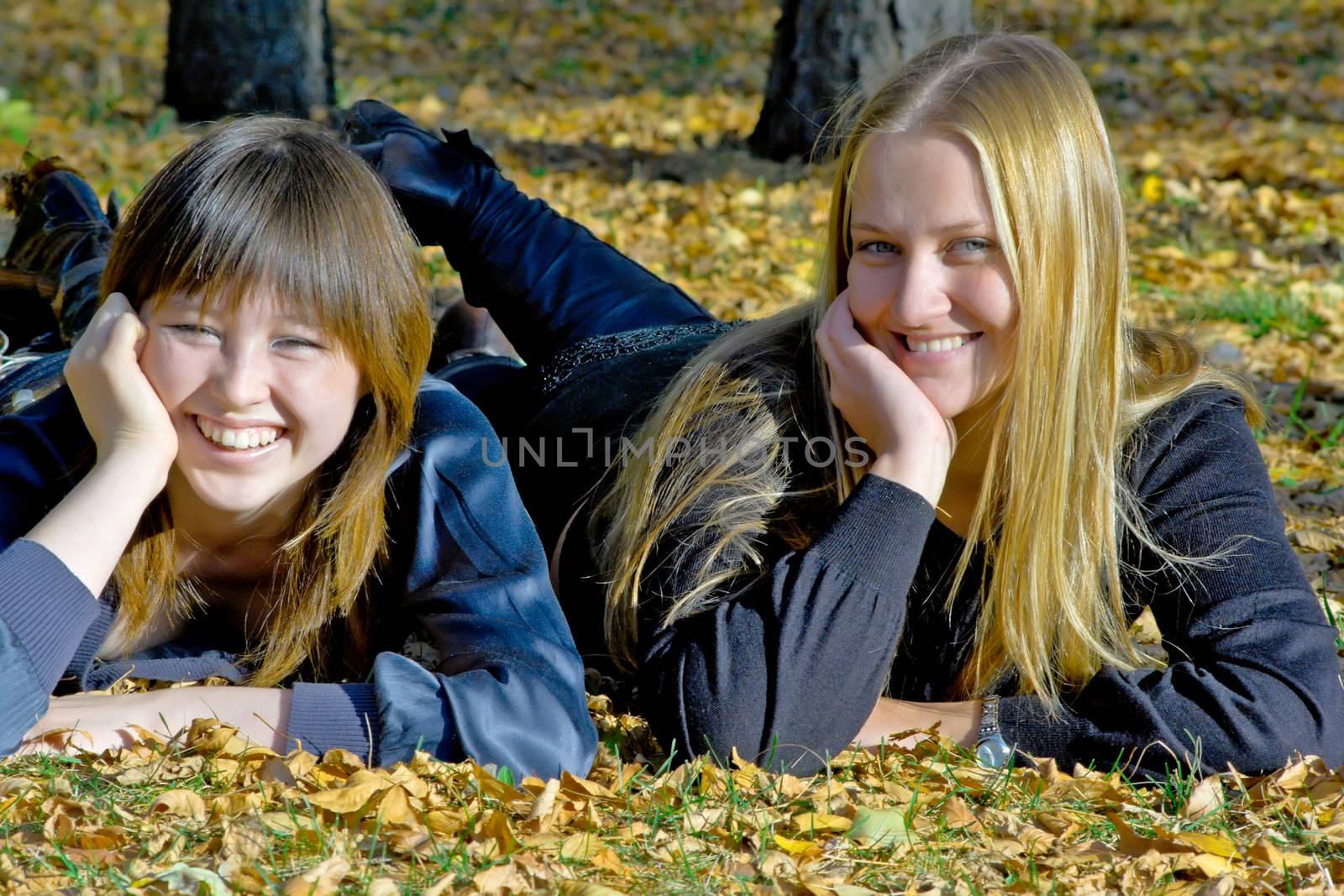 Two girlfriends against the autumn nature