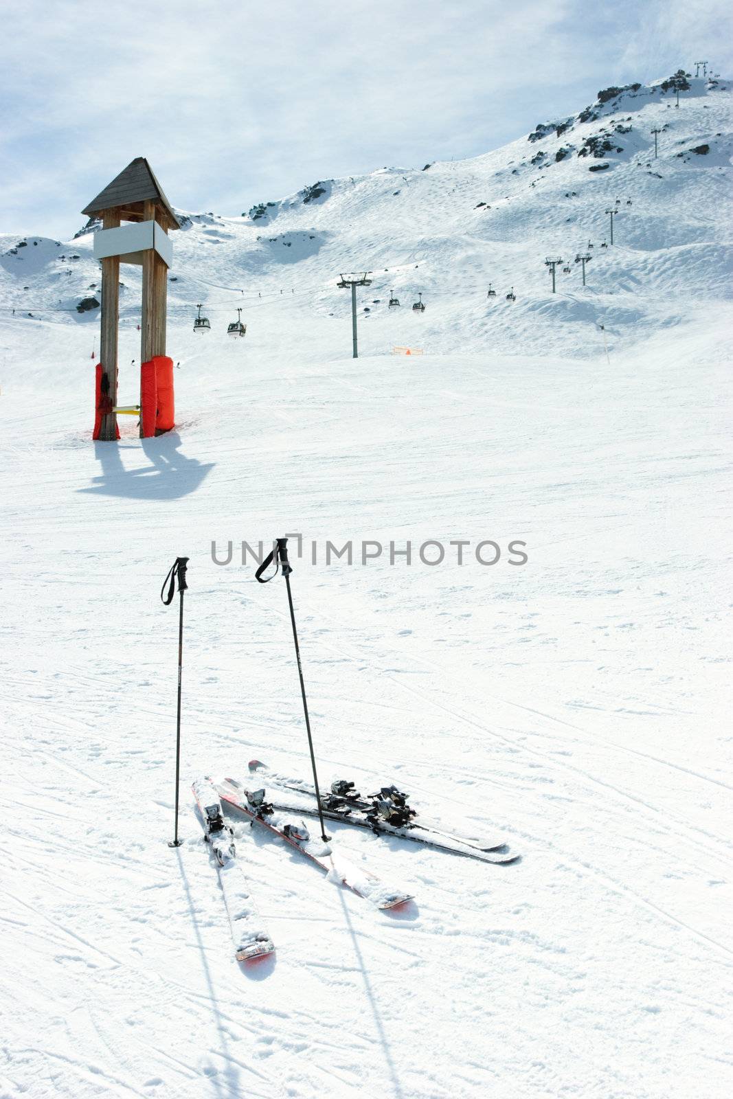 Blank signpost and skis on piste at ski resort