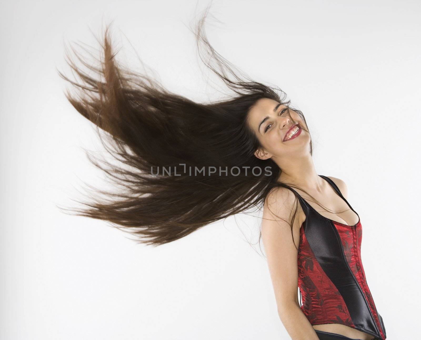 Caucasian woman wearing corset swinging her hair.