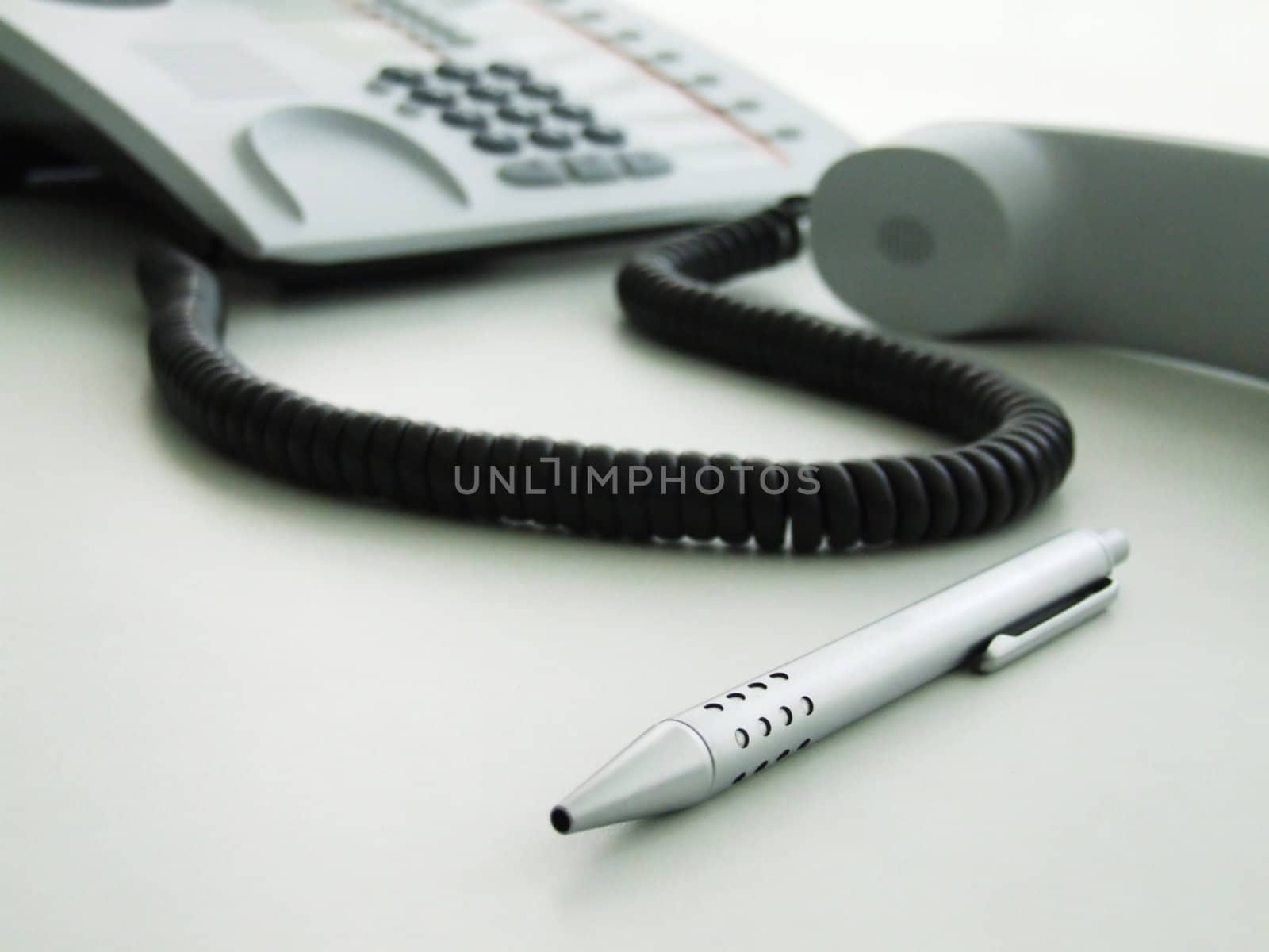 A phone and a pen on a table