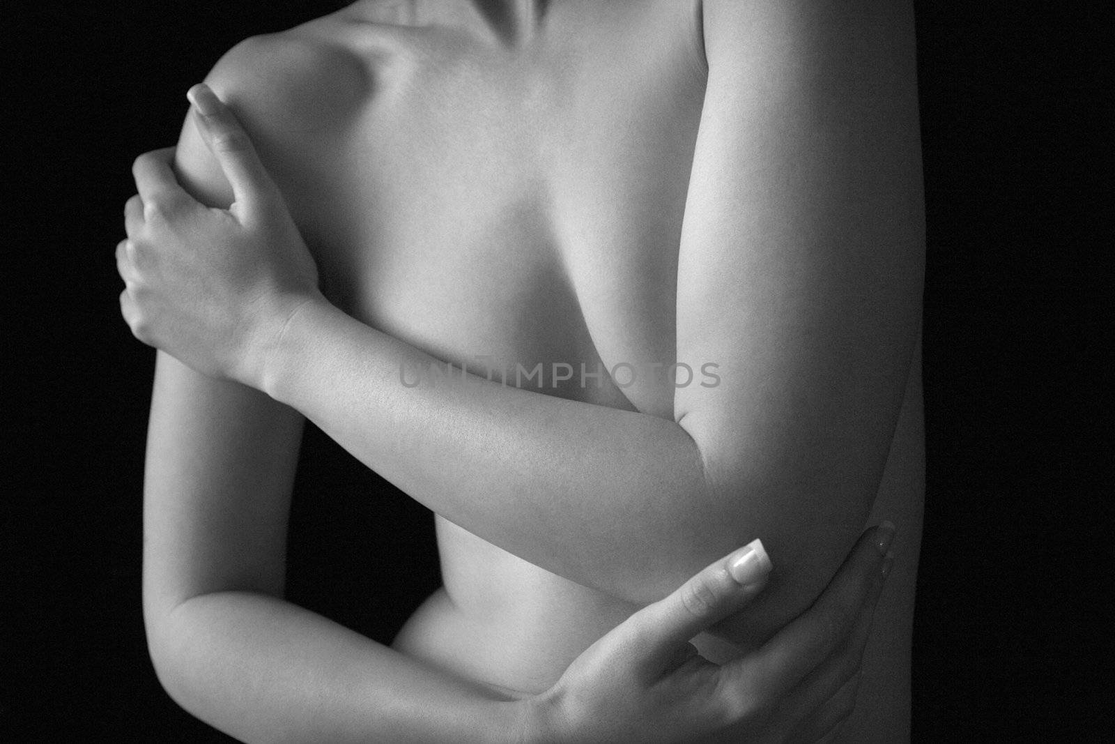 Nude young adult Caucasian female chest and arms.